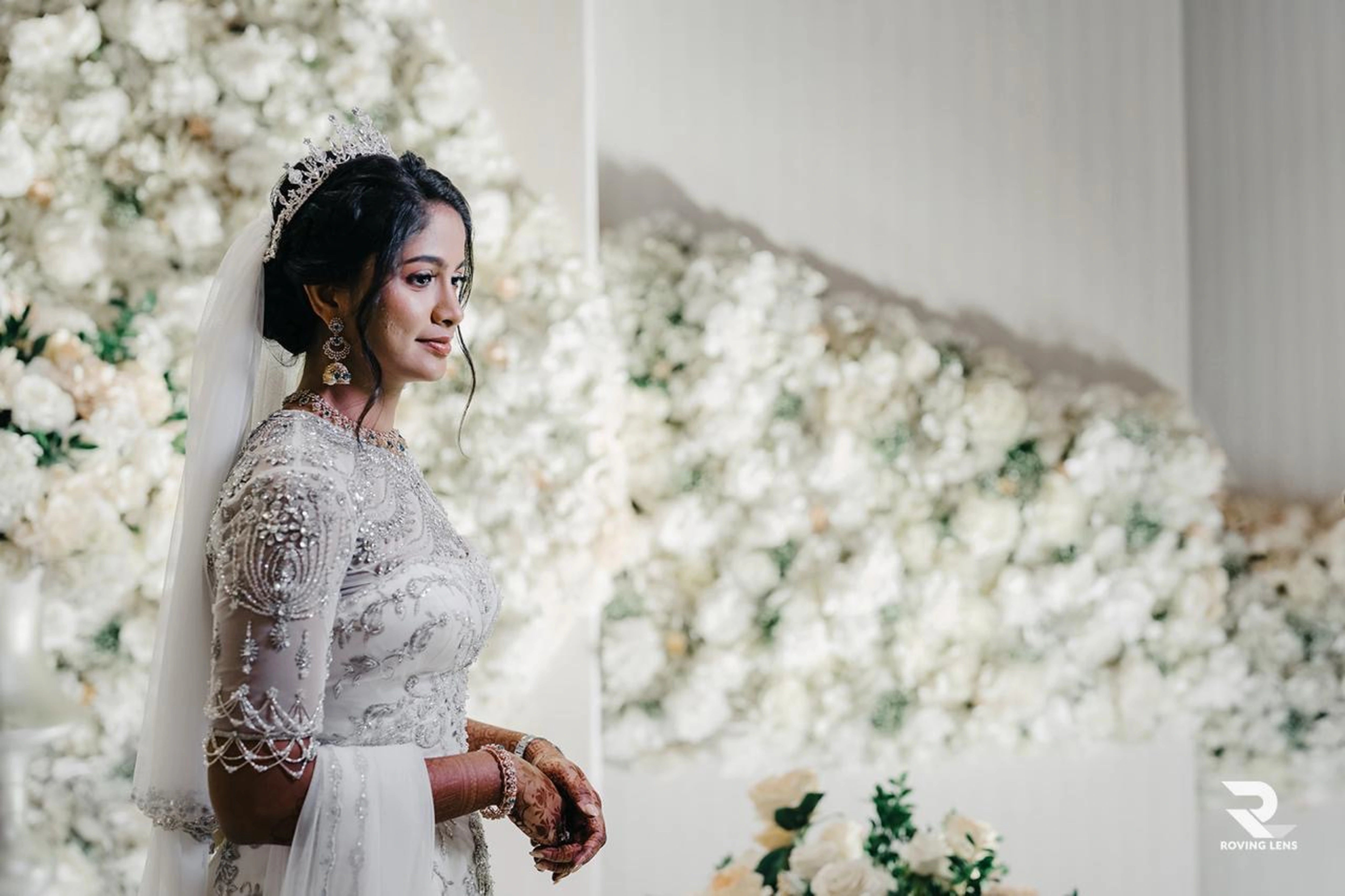 Bride Roushni smiling with the veil in a white gown for her church wedding by team Archana Karthick.