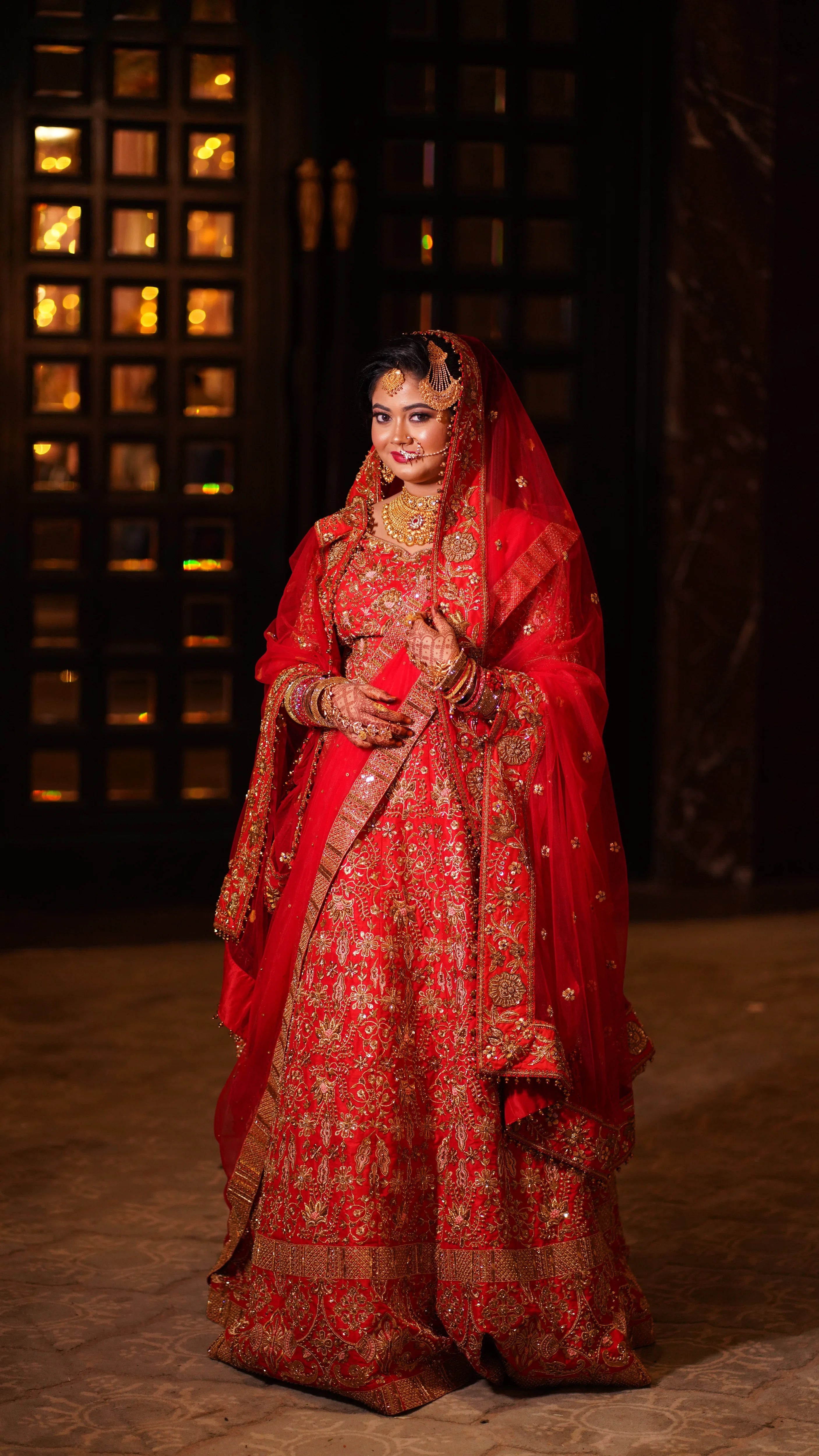 Bride Saba in a red raw silk lehenga with a veil and dupatta handcrafted by team Archana Karthick.