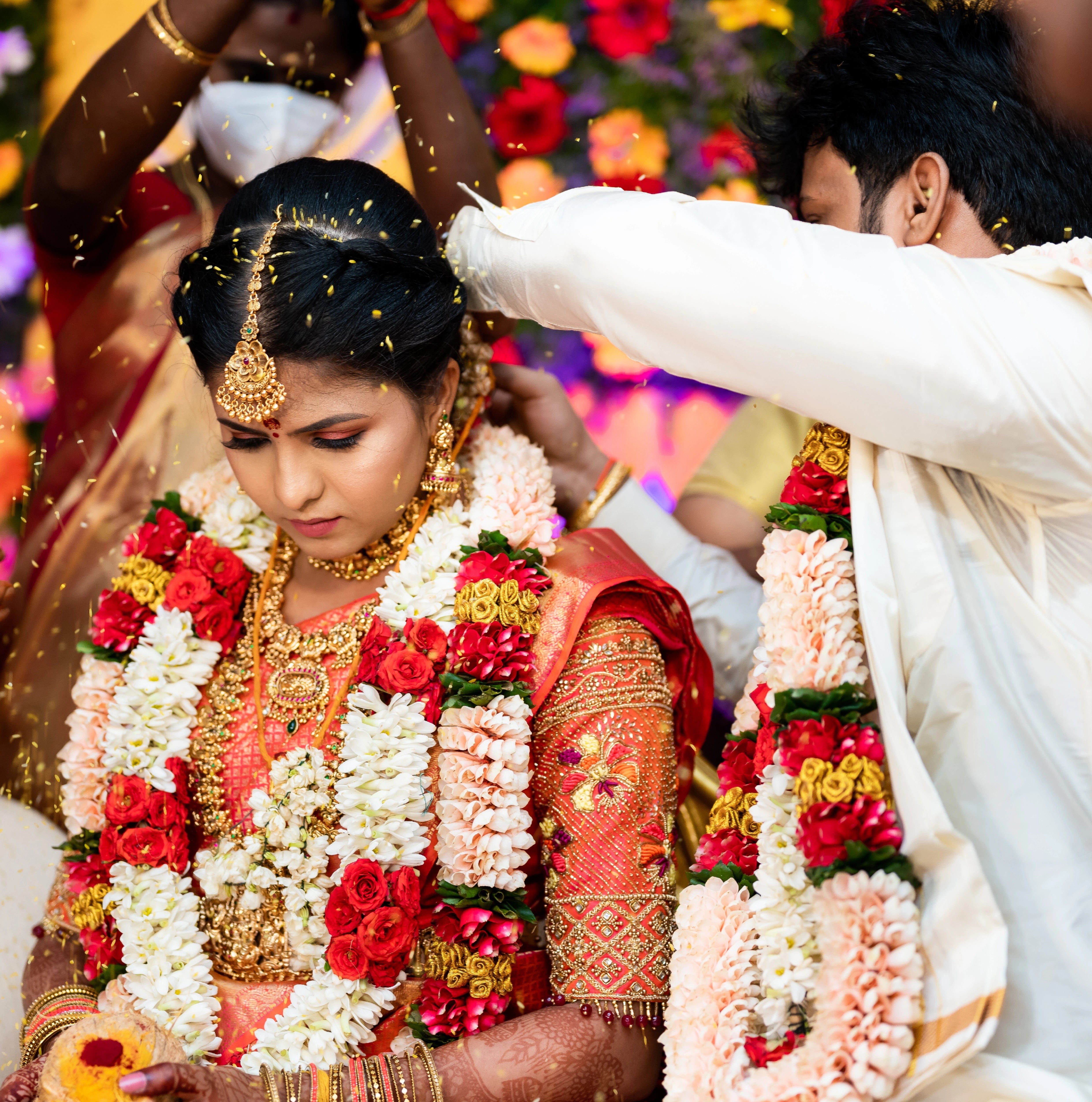 Bride Sarumathi during ritual in an orange silk blouse, intricately handcrafted with zardozi, resham, stones and beads by team Archana Karthick.