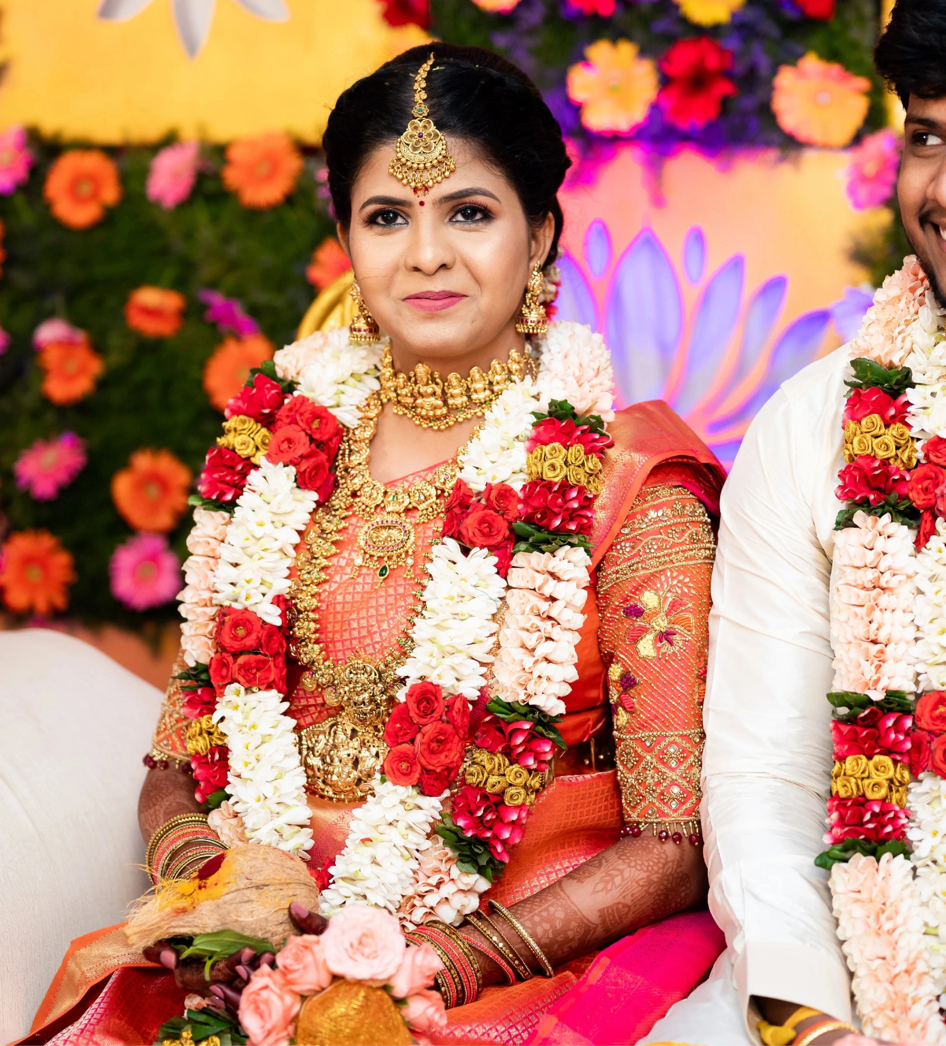 Bride Sarumathi in an orange silk blouse, intricately handcrafted with zardozi, resham, stones and beads by team Archana Karthick.