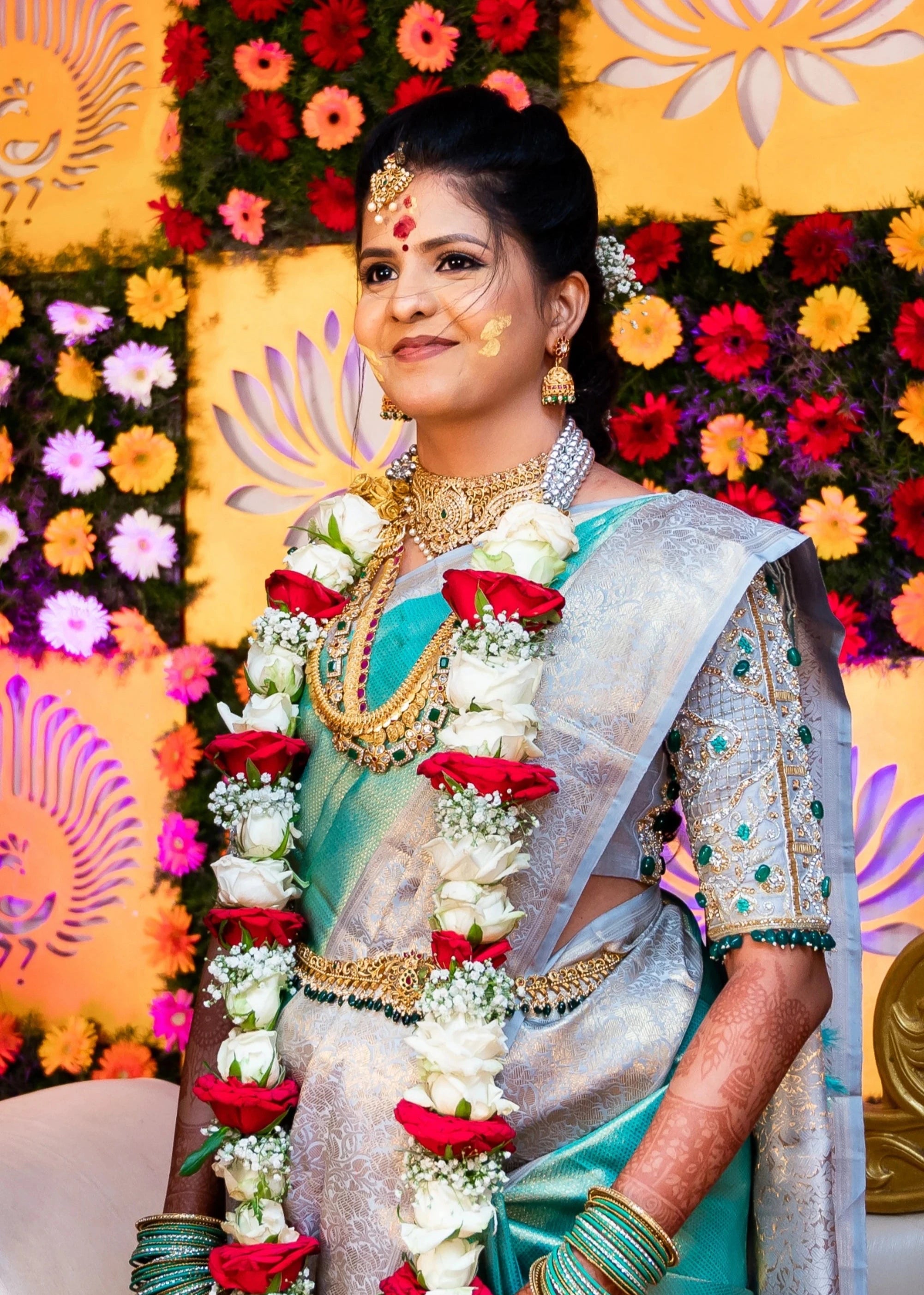 Bride Sarumathi smiling in a powder blue silk blouse, intricately handcrafted with zardozi, resham, stones and cutdana by team Archana Karthick.