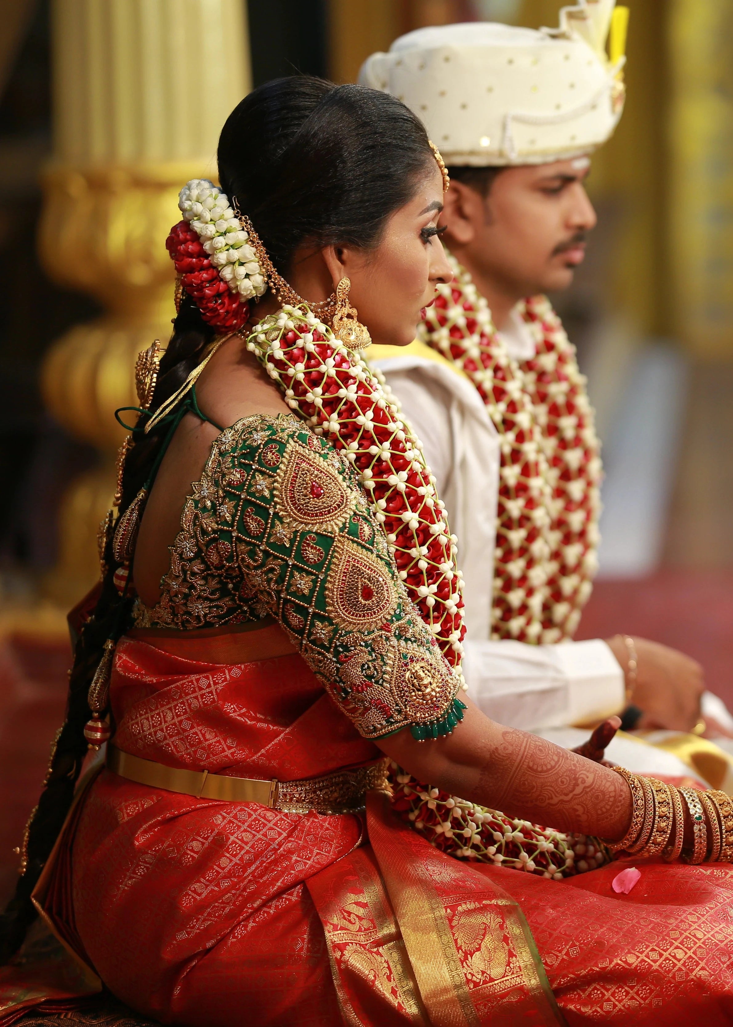 Bride Shanmuga Priya sitting for ritual in a bottle green silk blouse for her wedding, handcrafted with beads, zardozi, kundan and crystals by team Archana Karthick.