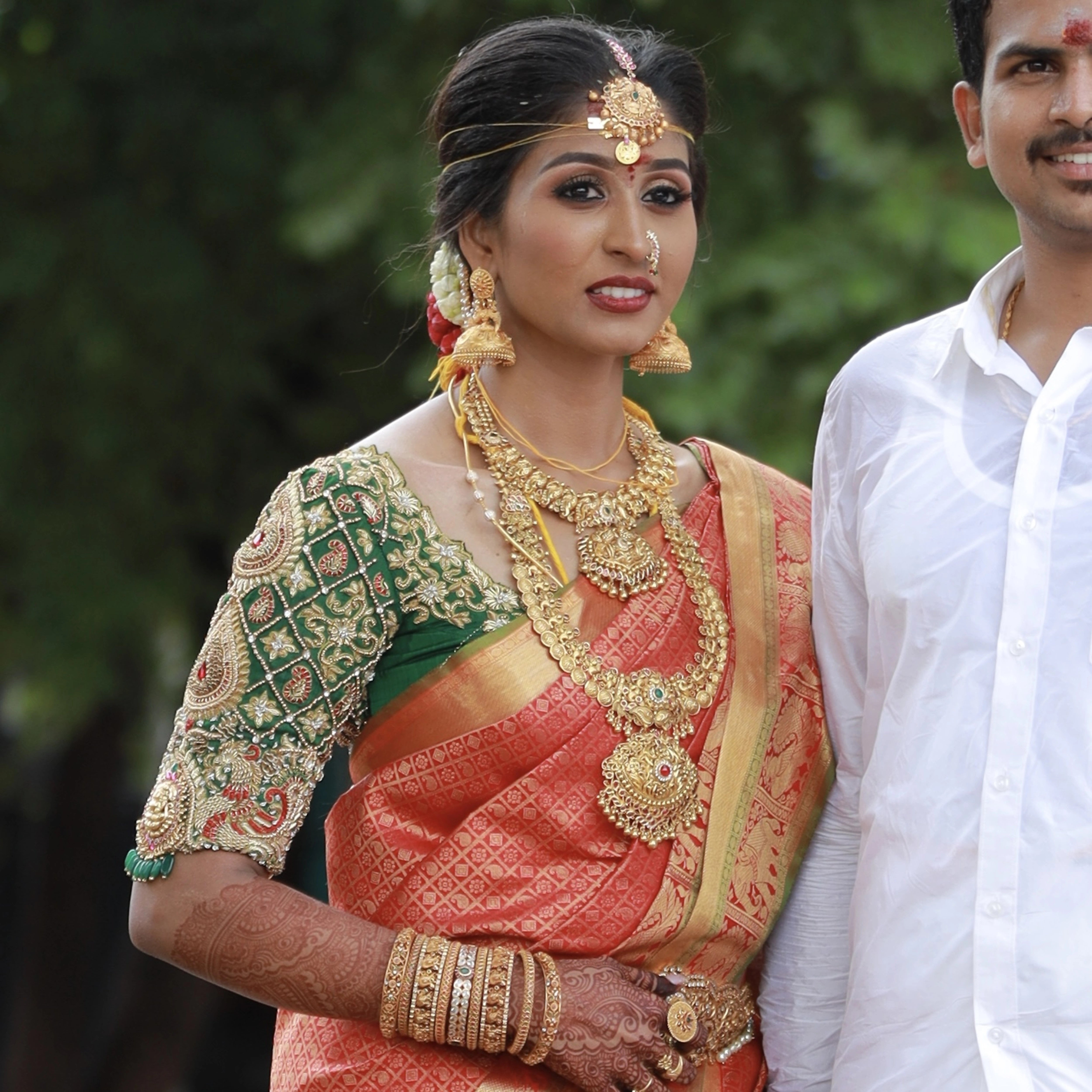 Bride Shanmuga Priya with groom in a bottle green silk blouse for her wedding, handcrafted with beads, zardozi, kundan and crystals by team Archana Karthick.