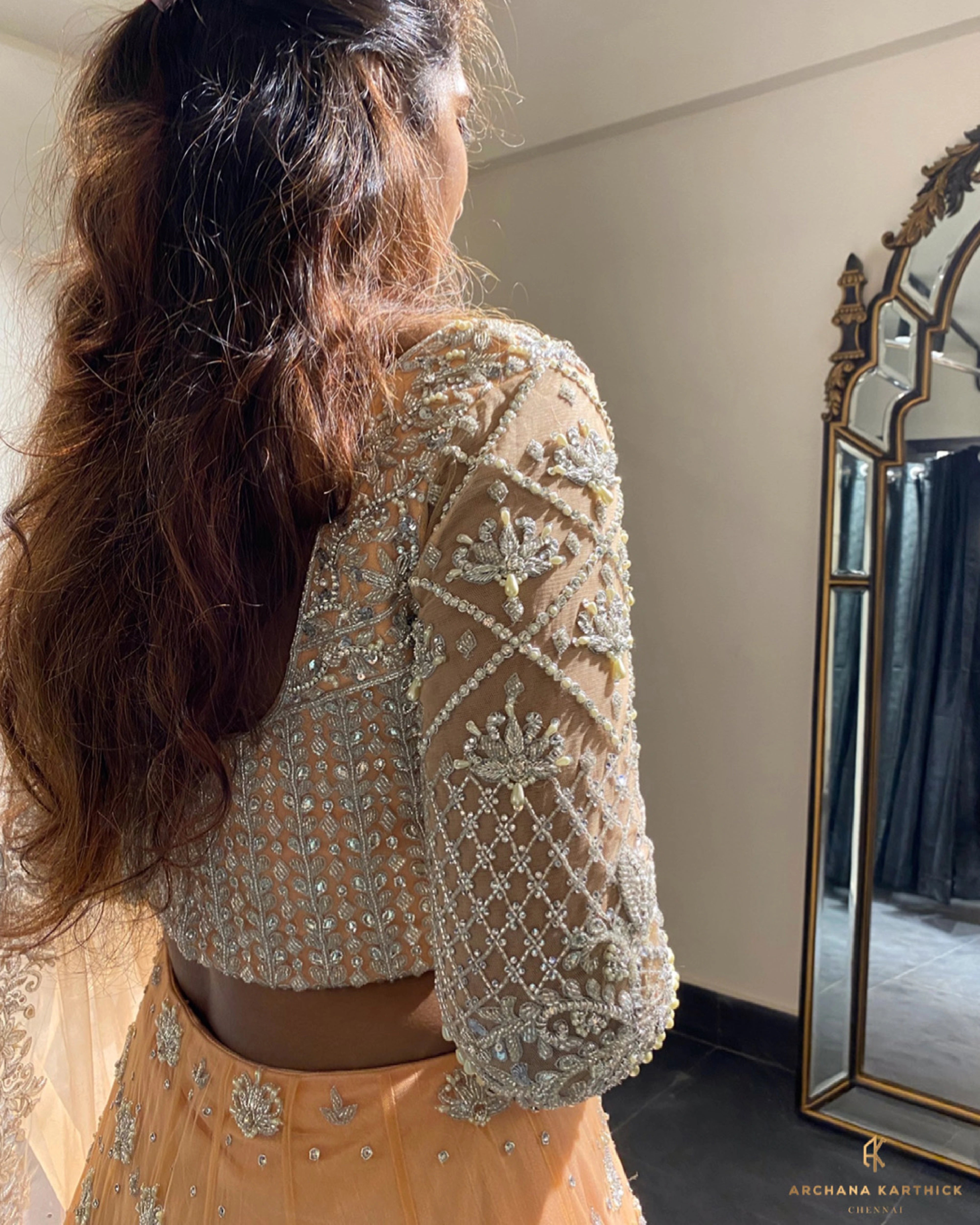 Bride Shanmugapriya during fittings in a peach tulle reception lehenga, handcrafted by team Archana Karthick.