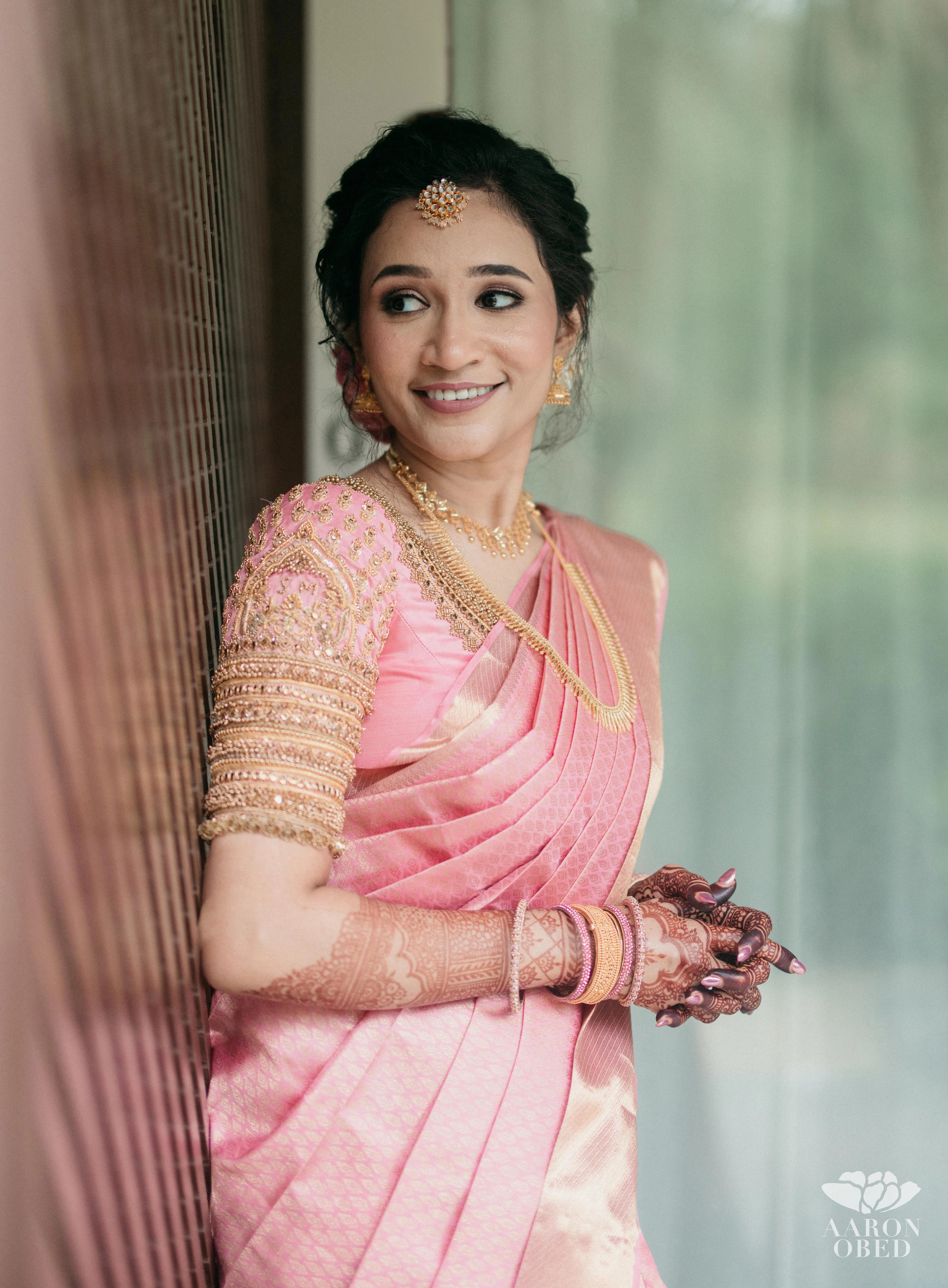 Bride Sharon Jacob during photoshoot in a pink silk blouse, intricately handcrafted with zardozi, stones, sequins and beads by team Archana Karthick.