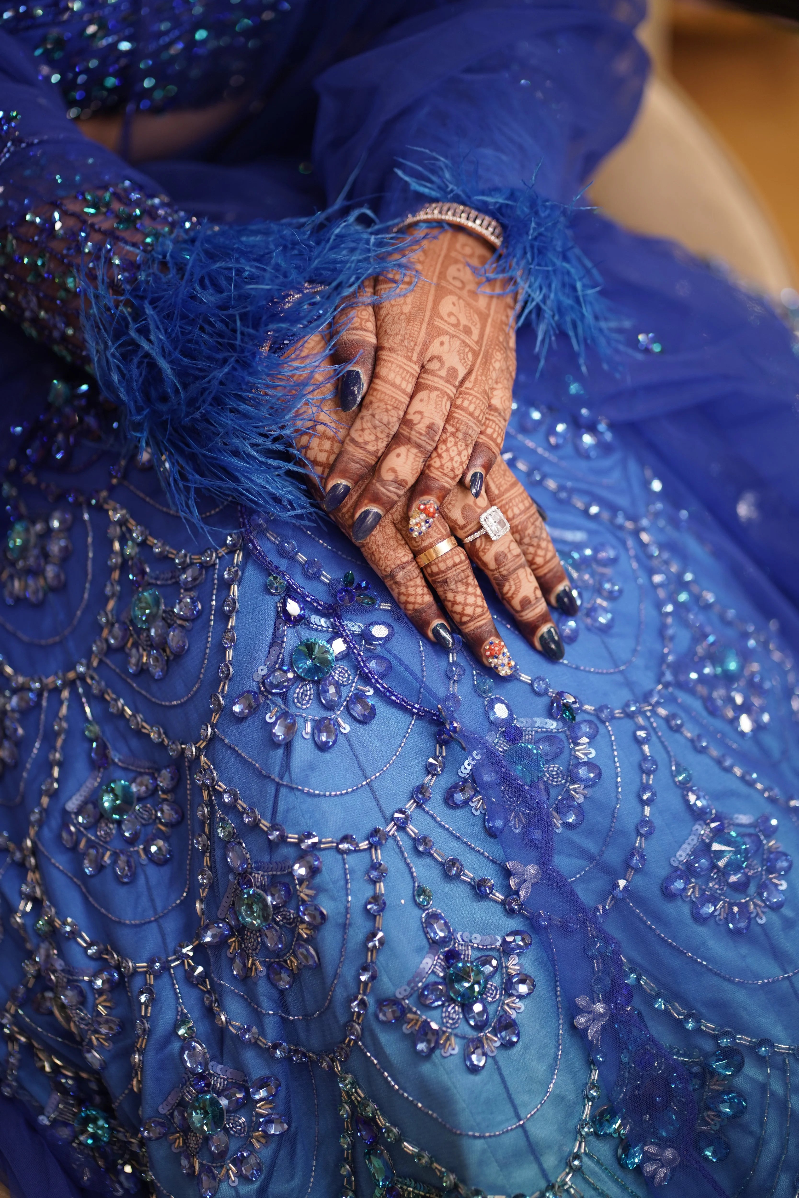 Bride Sharon posing for diamond wedding ring in a peacock themed blue lehenga by Archana Karthick