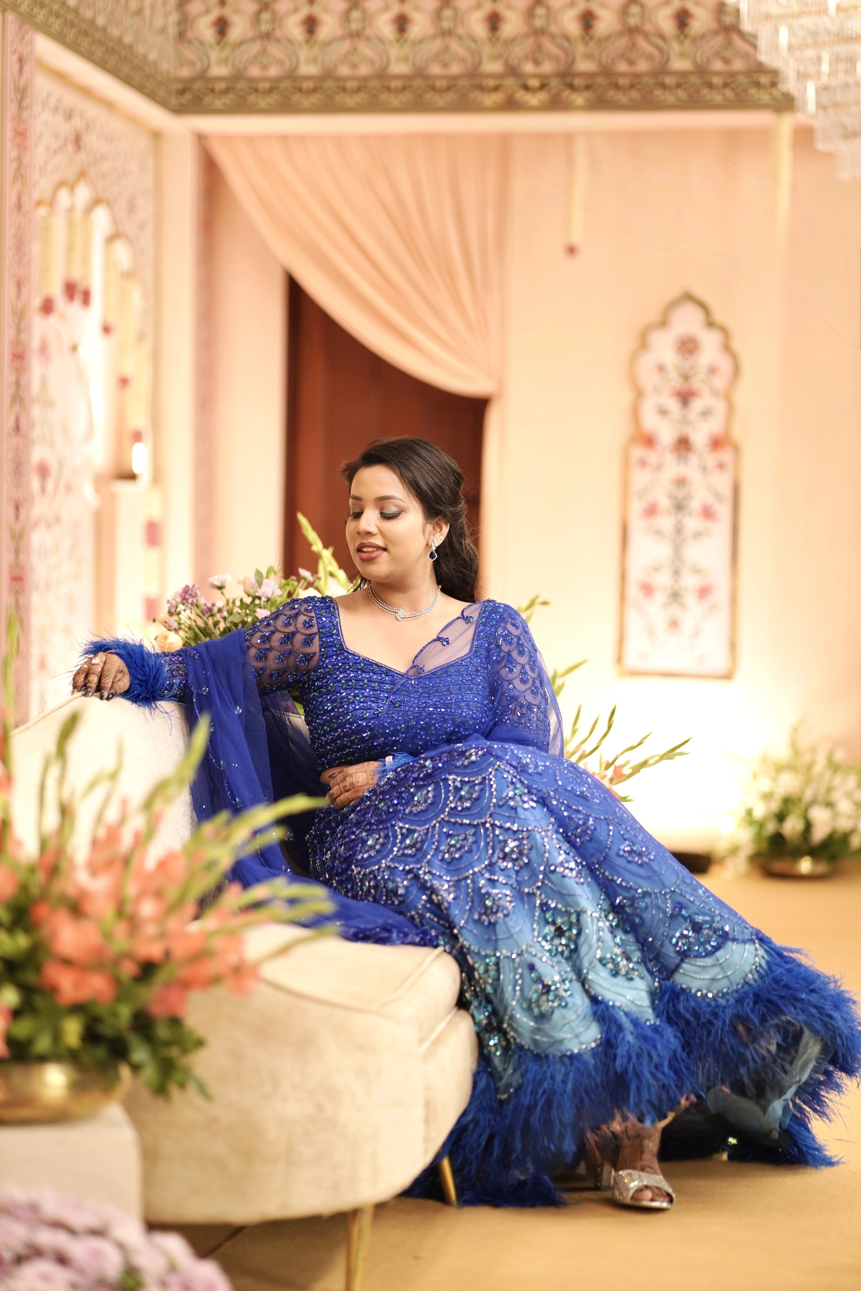 Bride Sharon posing on stage in a peacock themed blue lehenga by Archana Karthick