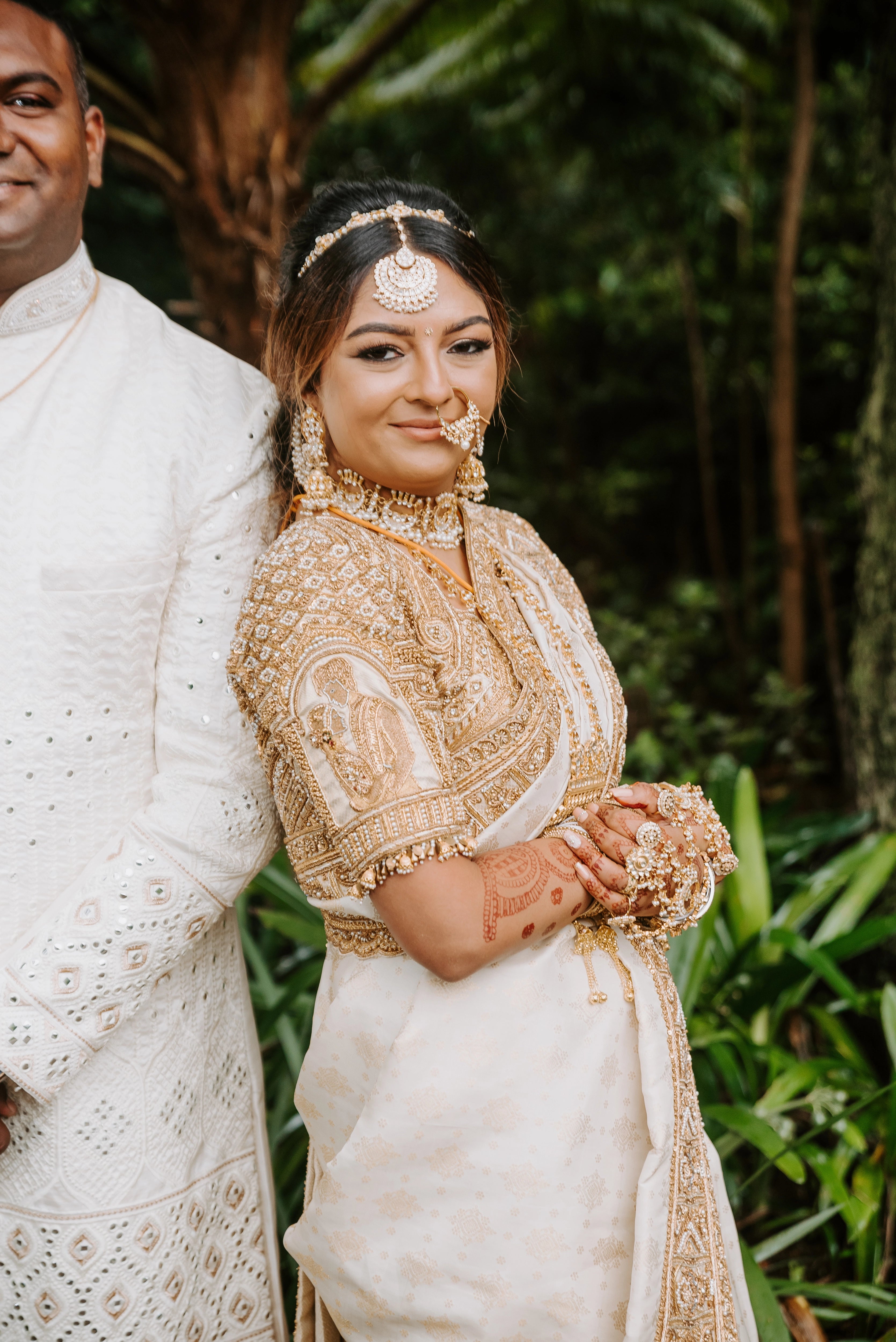 Bride Shayal Raniga posing with groom in an ivory silk concept blouse & saree border, intricately handcrafted with zardozi, stones, pearls and coins by team Archana Karthick.