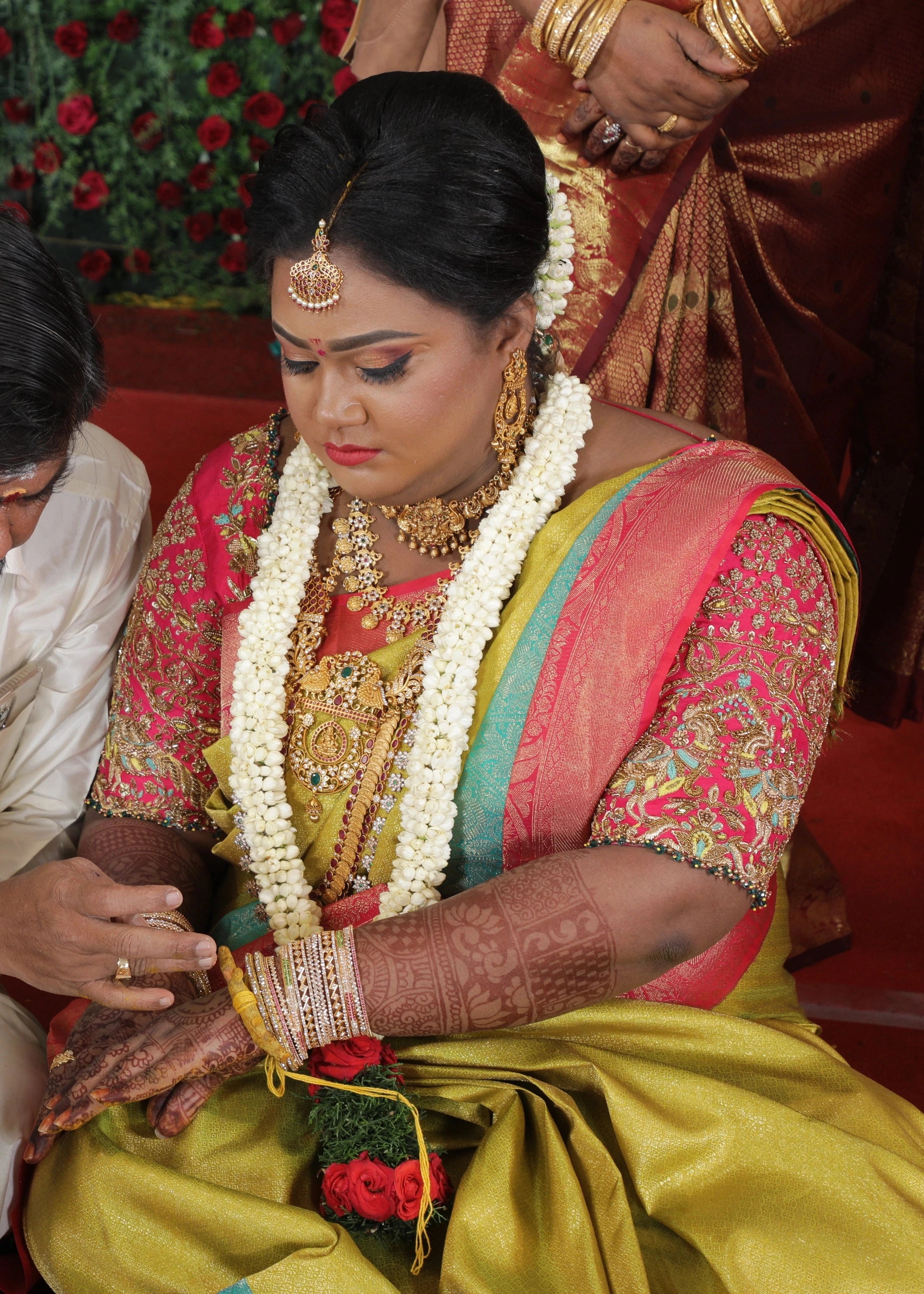 Bride Shyamaladevi dueing ritual in a hot pink raw silk blouse, intricately handcrafted with beads, cutdana, stones, resham, sequins and zardozi by team Archana Karthick.