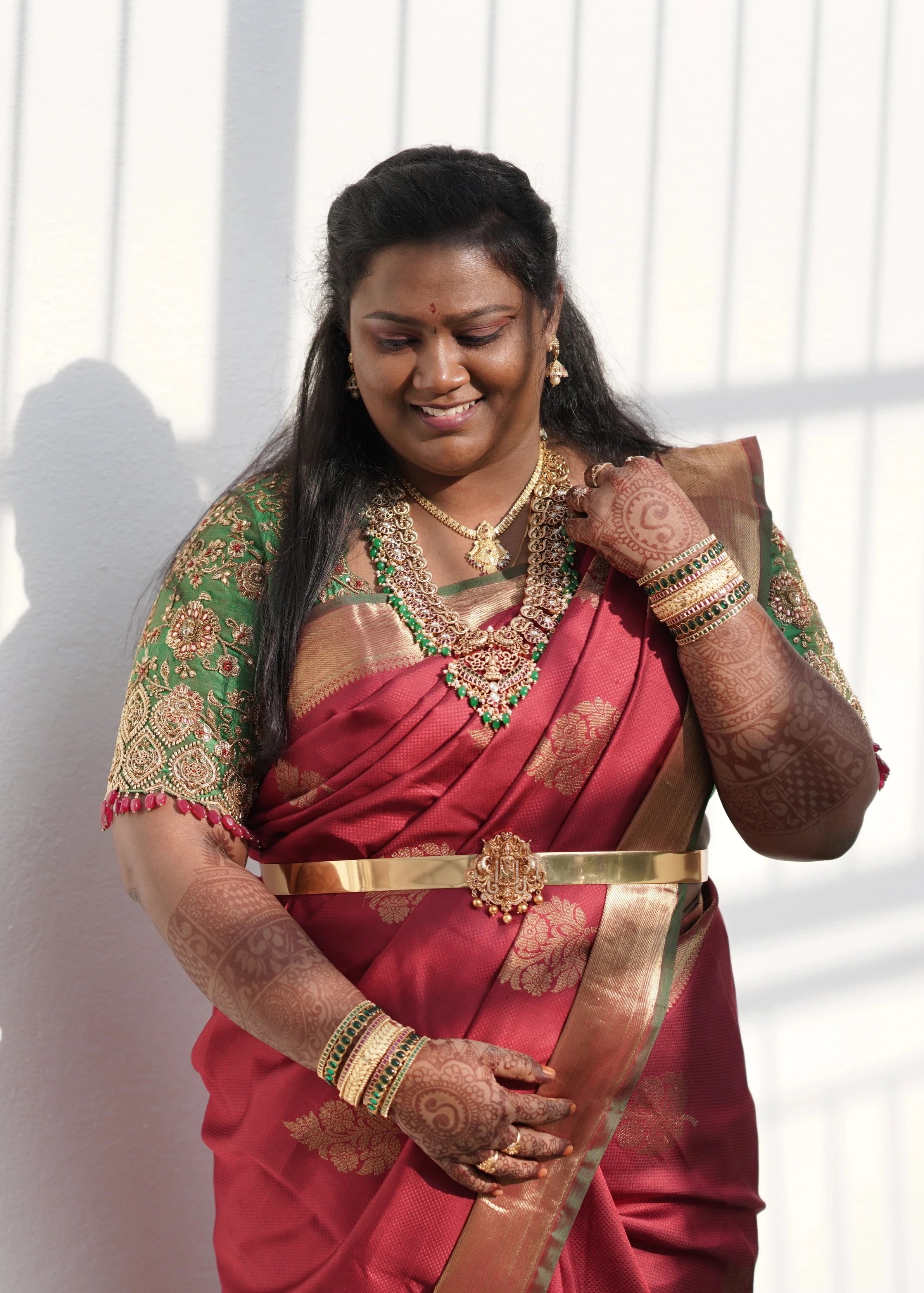 Bride Shyamaladevi in a green raw silk blouse, intricately handcrafted with beads, kundan, stones and zardozi by team Archana Karthick.