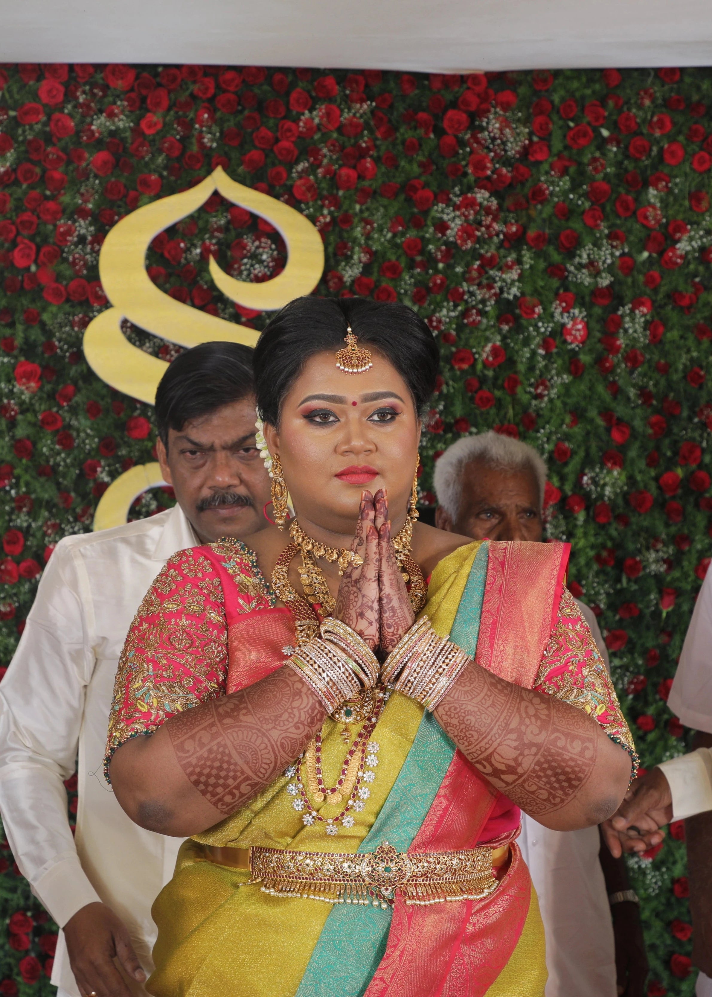 Bride Shyamaladevi posing in a hot pink raw silk blouse, intricately handcrafted with beads, cutdana, stones, resham, sequins and zardozi by team Archana Karthick.