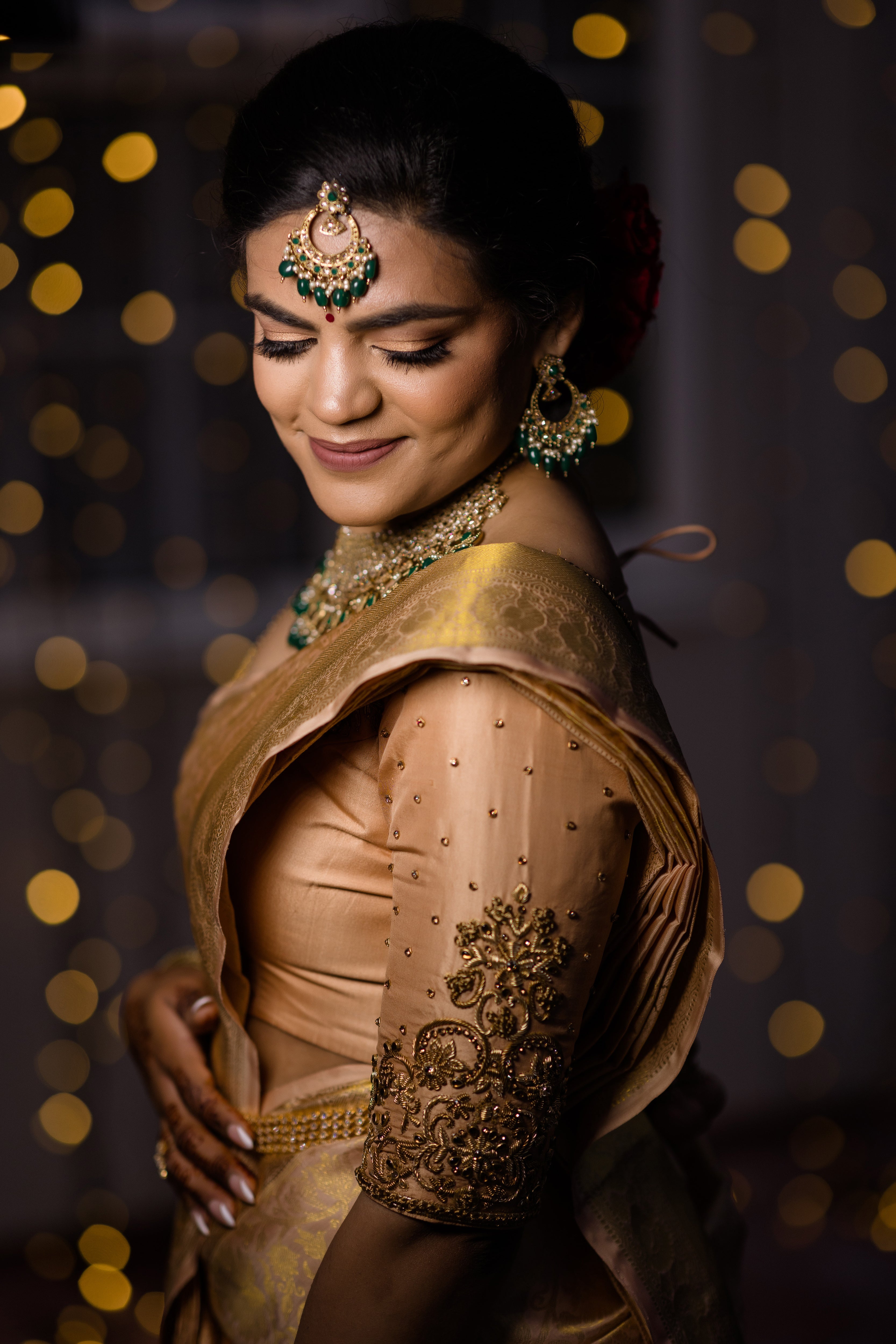 Bride Sinthuja from Middlesex, UK in a handcrafted silk blouse designed by Archana Karthick. Looking down to her left shyly.