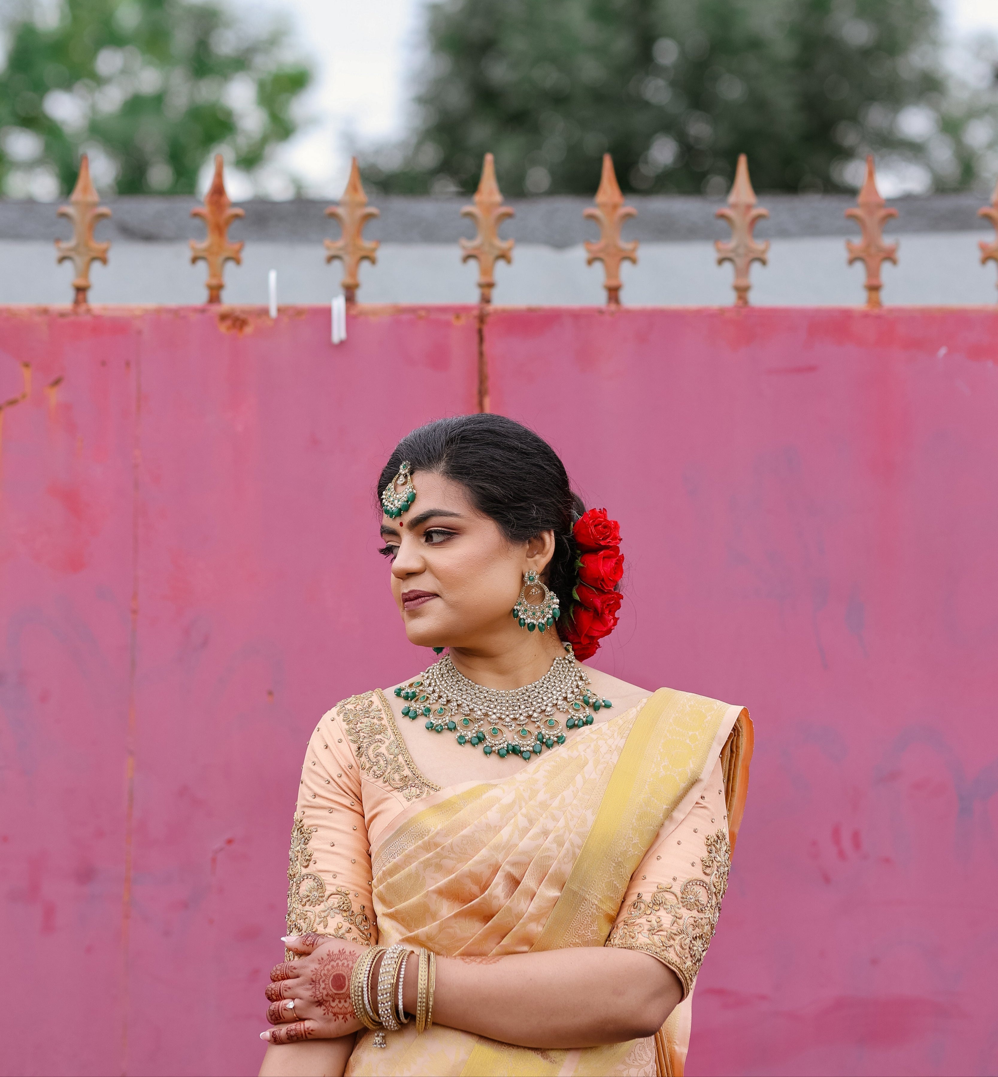 Bride Sinthuja from Middlesex, UK in a handcrafted silk blouse designed by Archana Karthick. Looking to her right with one arm on the other.