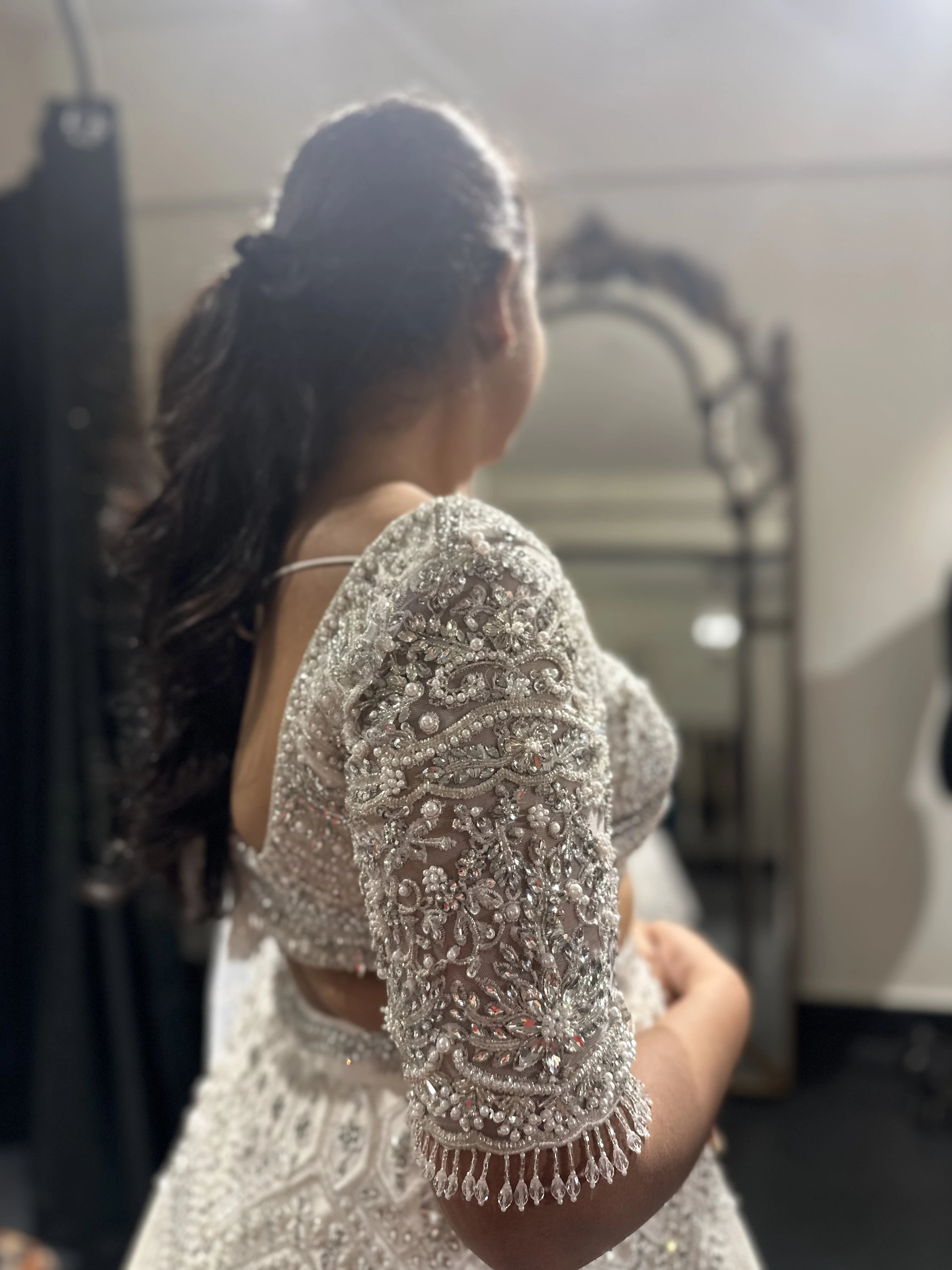 Bride Sneha from Chennai posing in a silver raw silk lehenga, intricately handcrafted with zari, cutdana, zardozi, crystals and stones by team Archana Karthick.