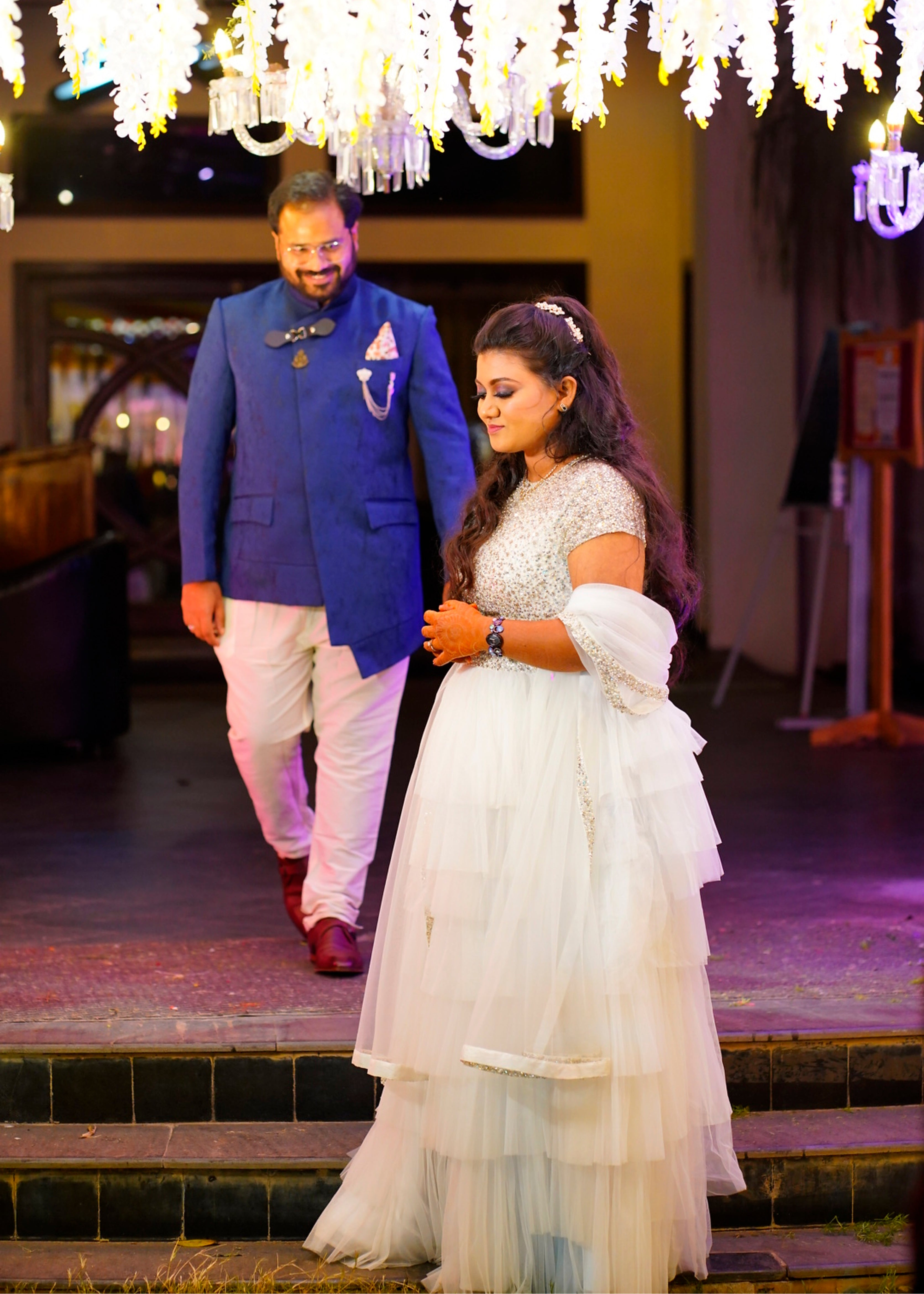 Bride Sowmya Rani from Hyderabad smiling for photo in a white lehenga handcrafted by team Archana Karthick.