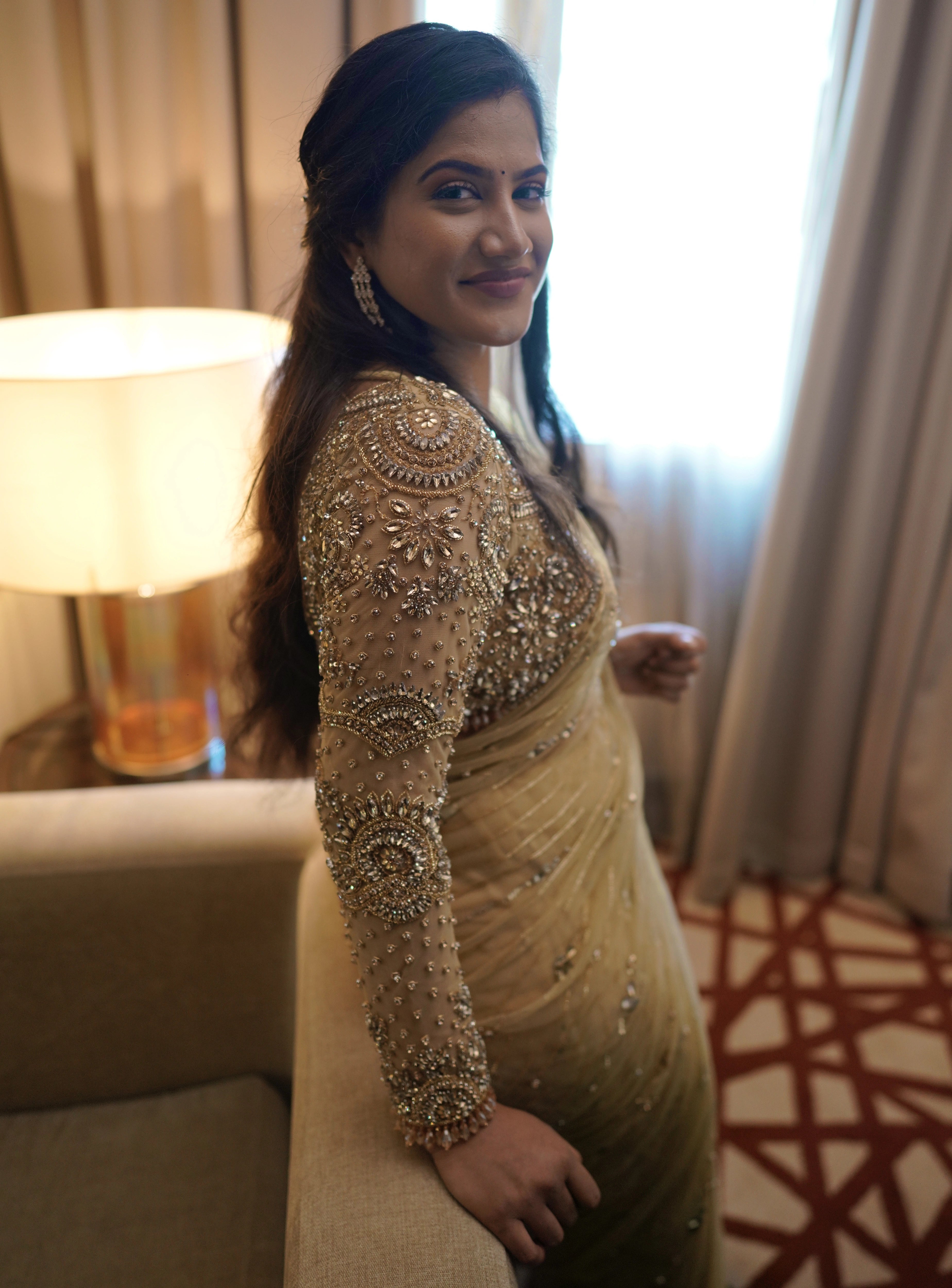 Bride Sree from Dubai, posing in a golden beige tulle saree handcrafted by team Archana Karthick.
