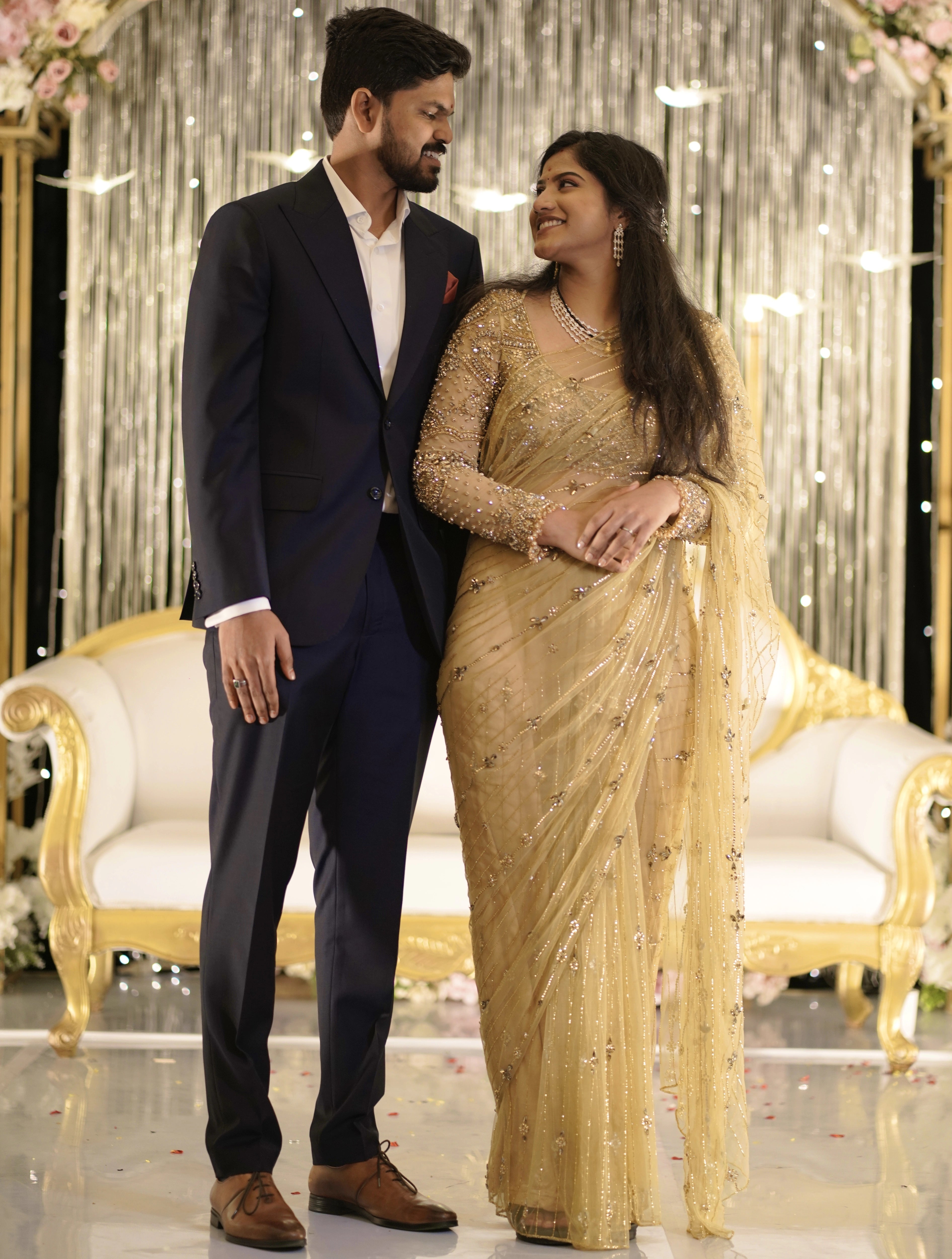 Bride Sree from Dubai, smiling om stage in a golden beige tulle saree handcrafted by team Archana Karthick.