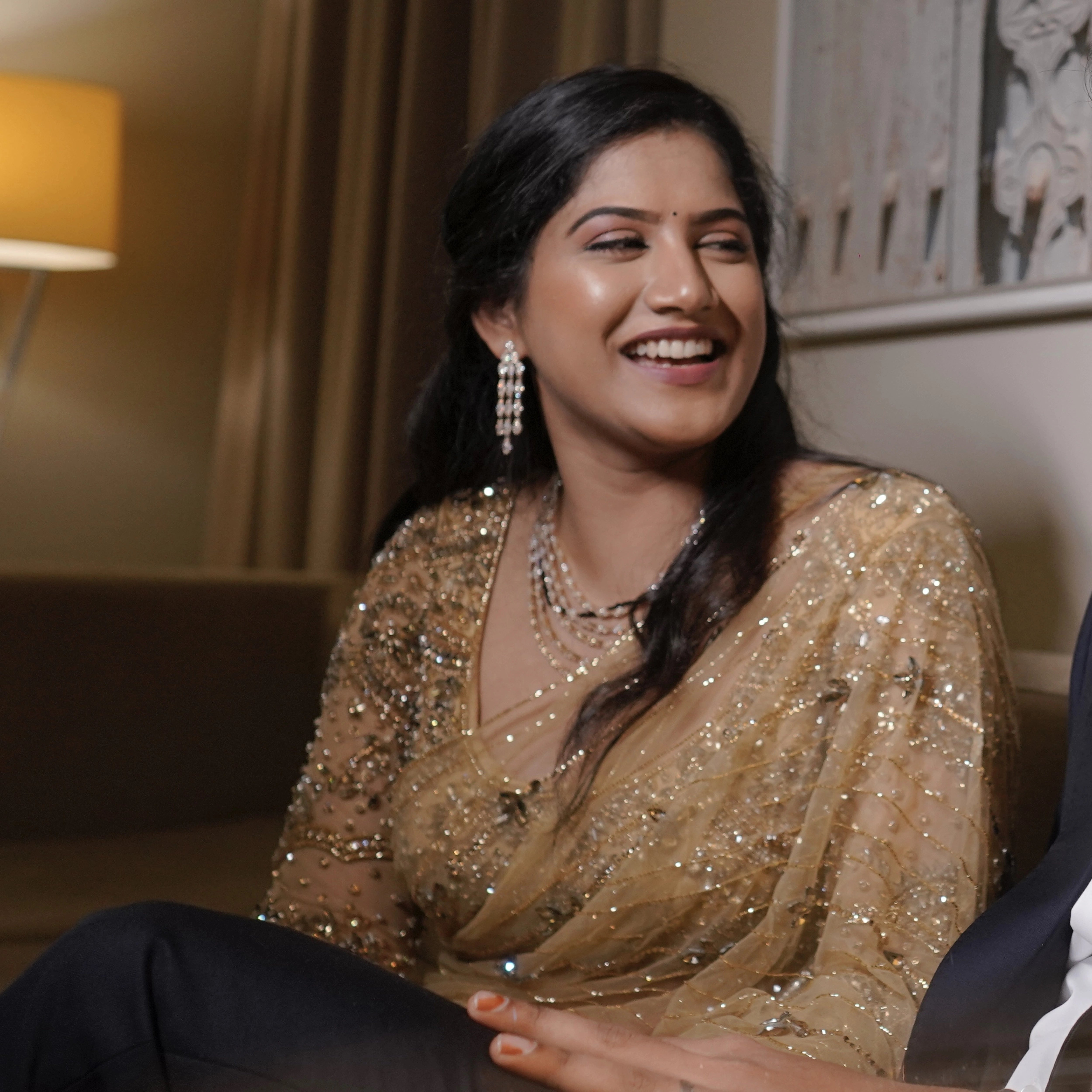 Bride Sree from Dubai, smiling with groom in a golden beige tulle saree handcrafted by team Archana Karthick.
