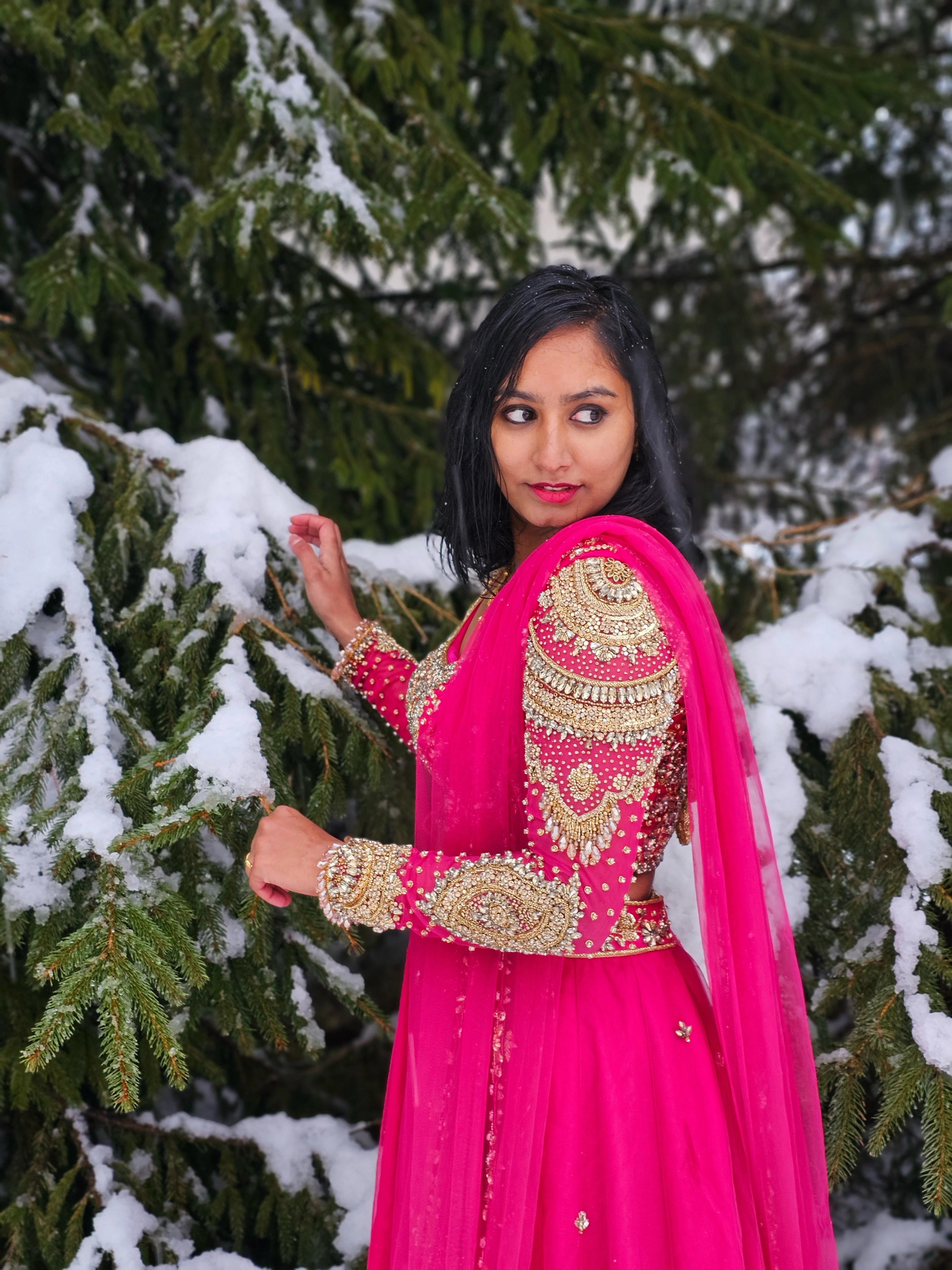 Bride Steffy from Italy, posing in snow in a pink tulle reception lehenga by team Archana Karthick.