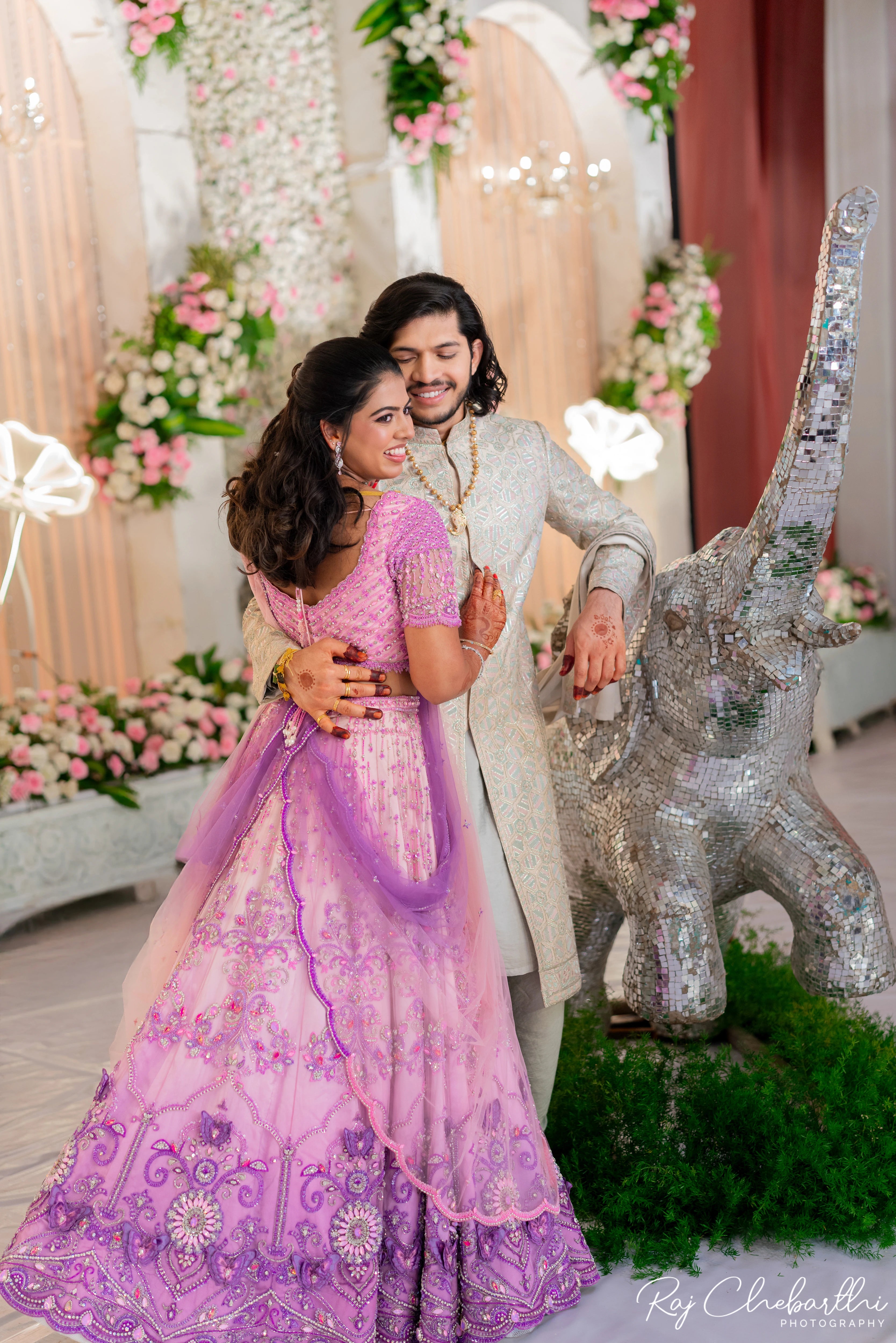 Bride Subhiksha from US smiling with groom in a lavender-pink lehenga by Archana Karthick