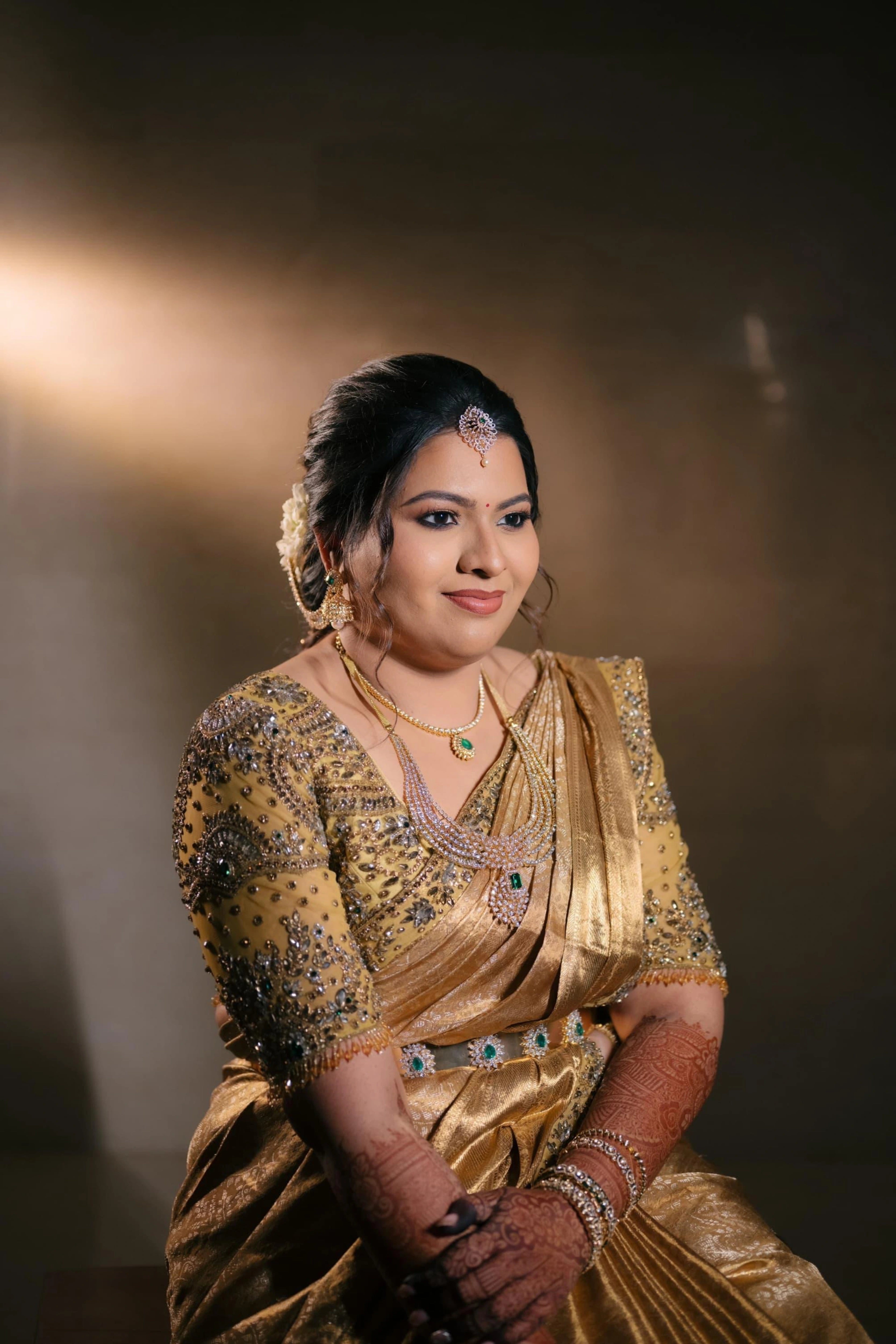 Bride Surrekha posing in a gold silk blouse and saree border by team Archana Karthick.