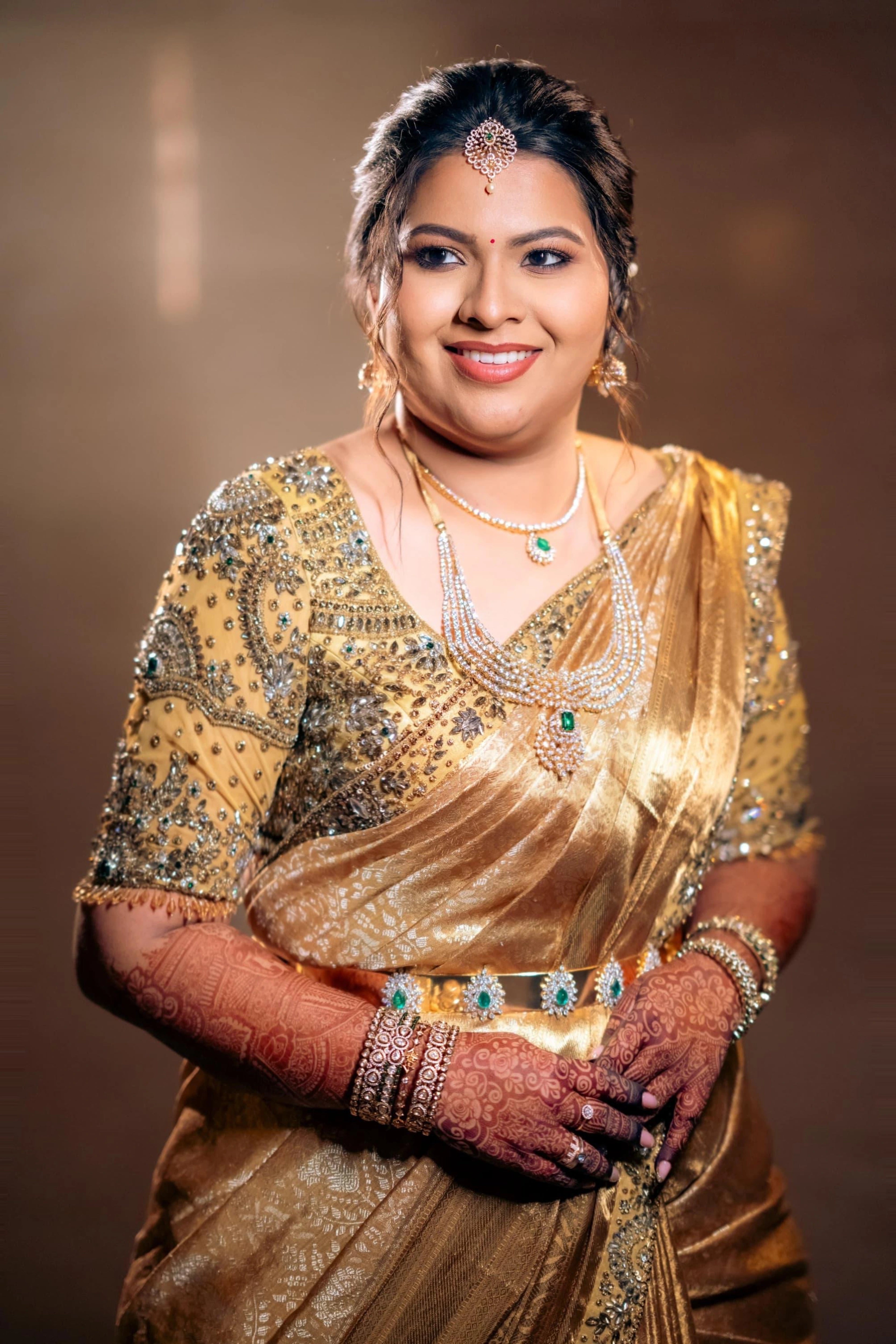 Bride Surrekha smiling in a gold silk blouse and saree border by team Archana Karthick.