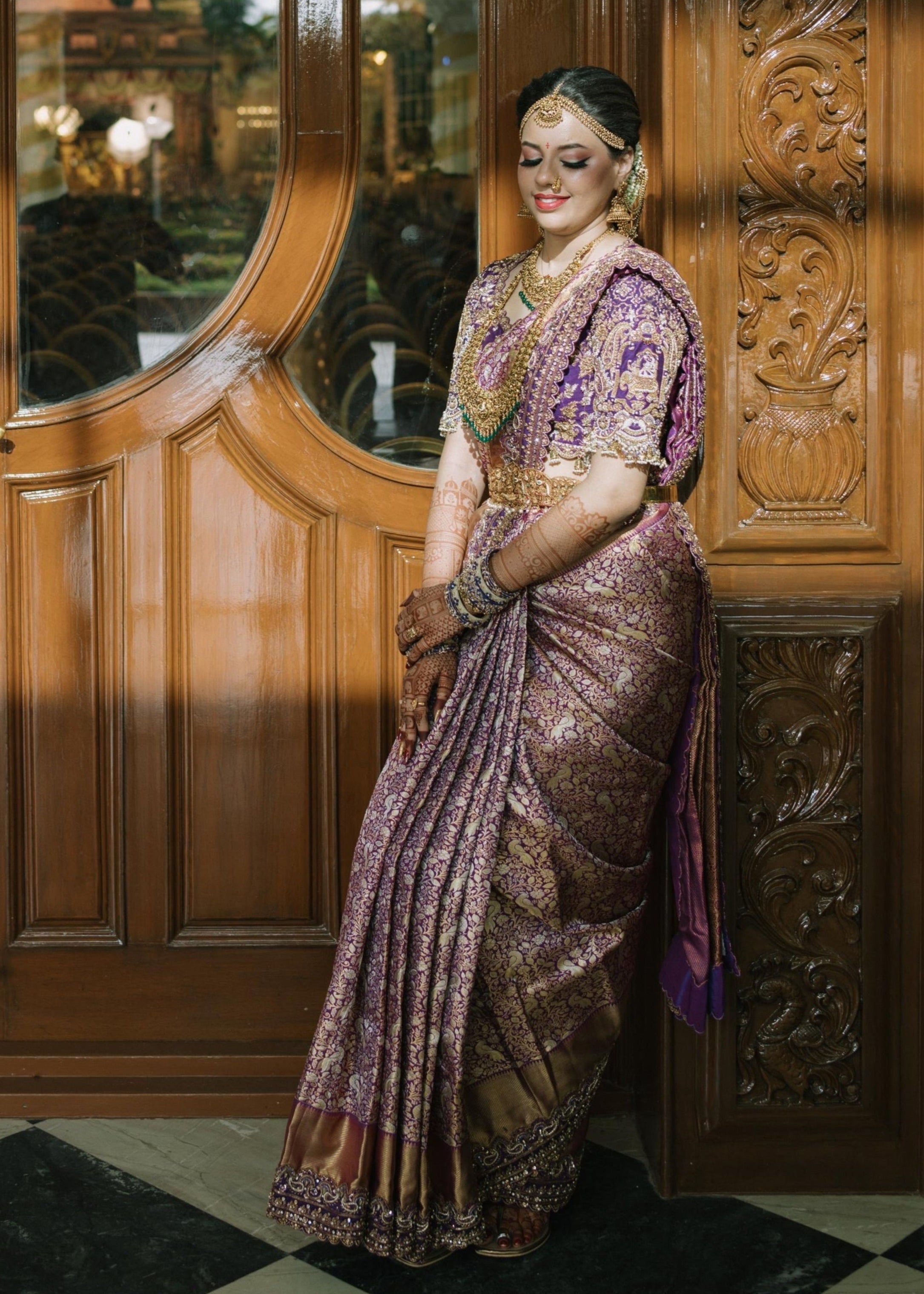 Bride Urmila posing elegantly in a handcrafted blouse and saree border for her wedding or muhurtham designed by Archana Karthick.