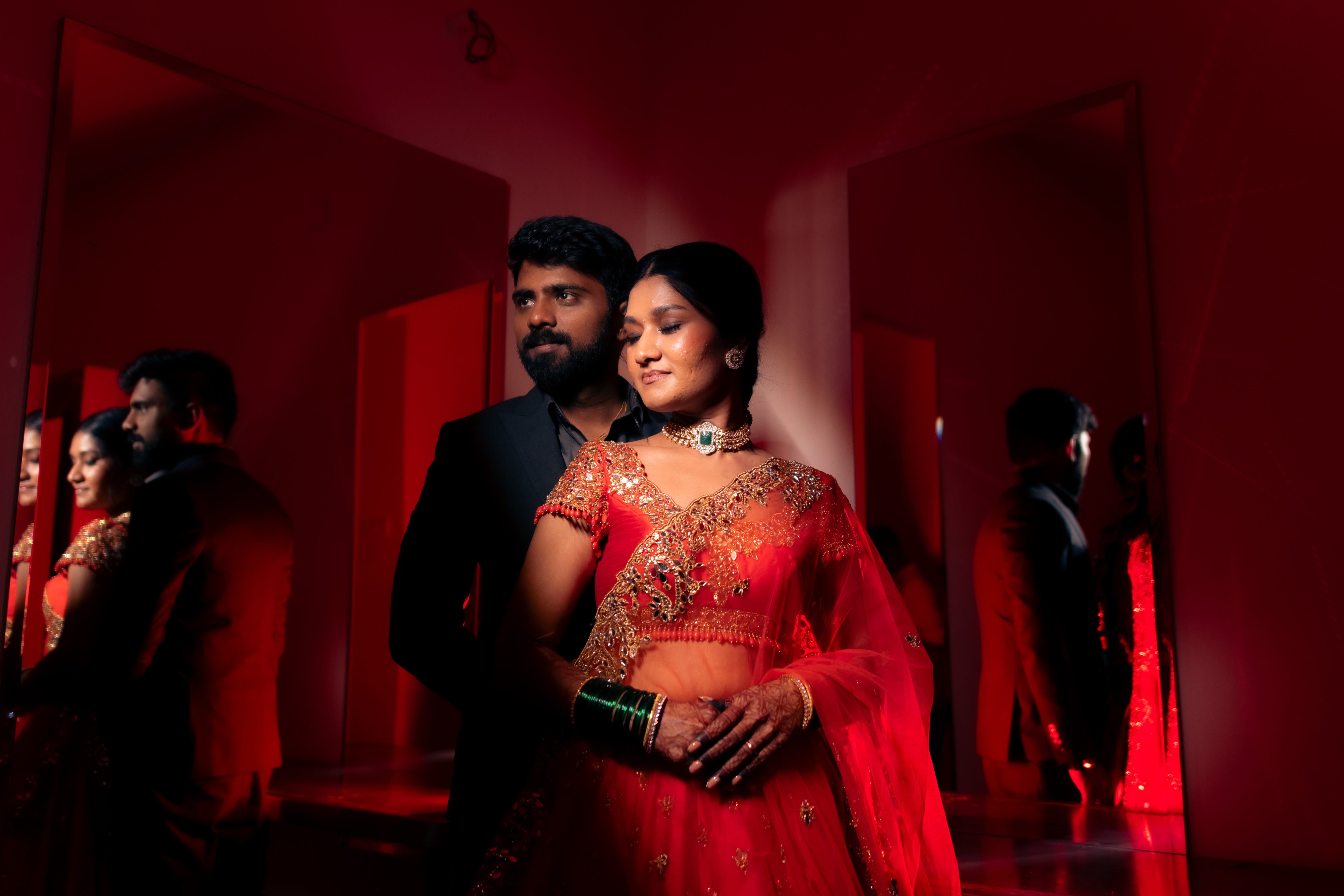 Bride Vaishali from Dubai, in a stunning mirror and zardozi worked orange lehenga designed by Archana Karthick. Here the bride is posing with the groom.