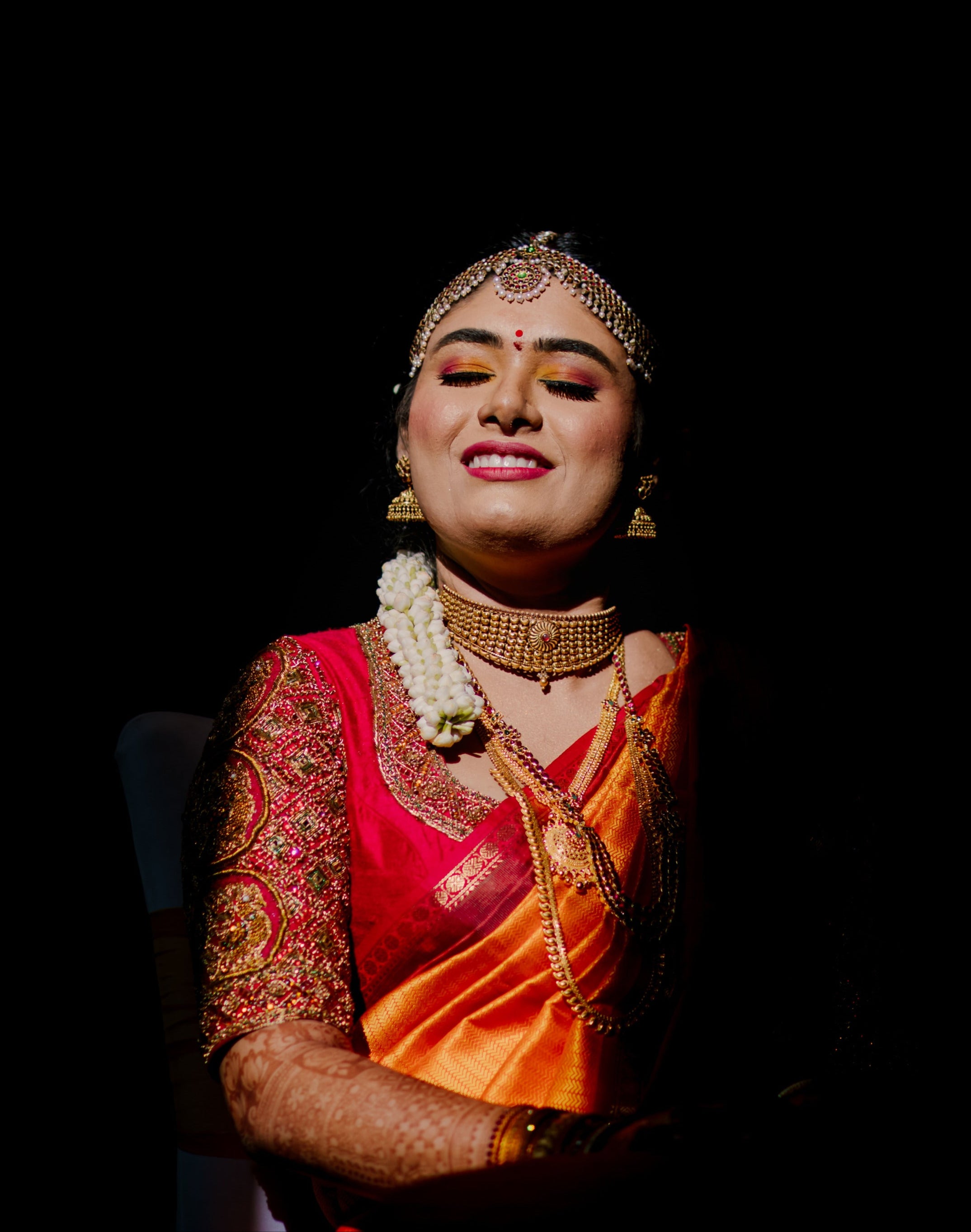 Bride Varshini in a handcrafted red silk blouse designed by Archana Karthick. Shadows used well to capture this puicture.