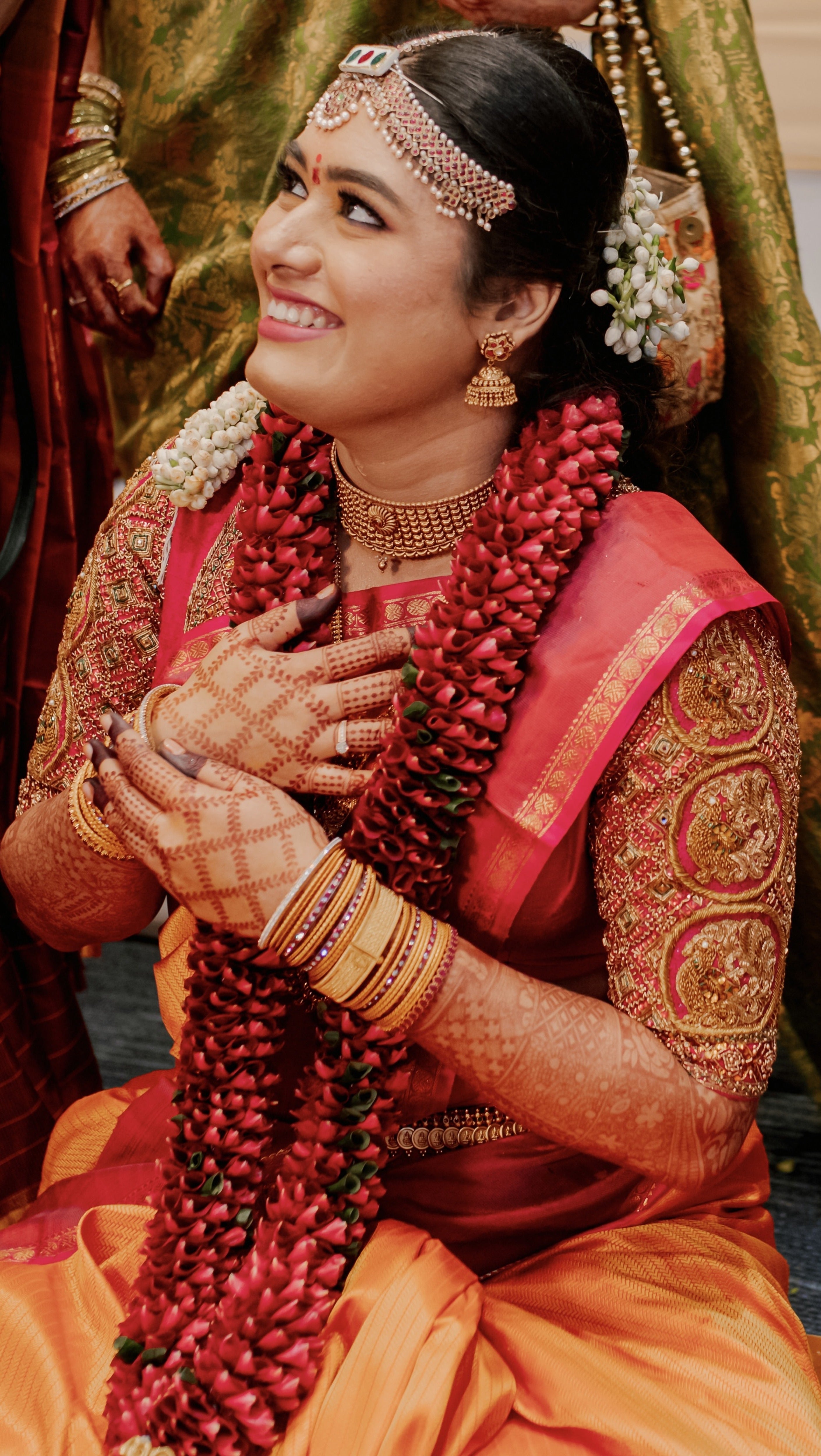 Bride Varshini in a handcrafted red silk blouse designed by Archana Karthick. She is in the middle of thanking the guests for coming.