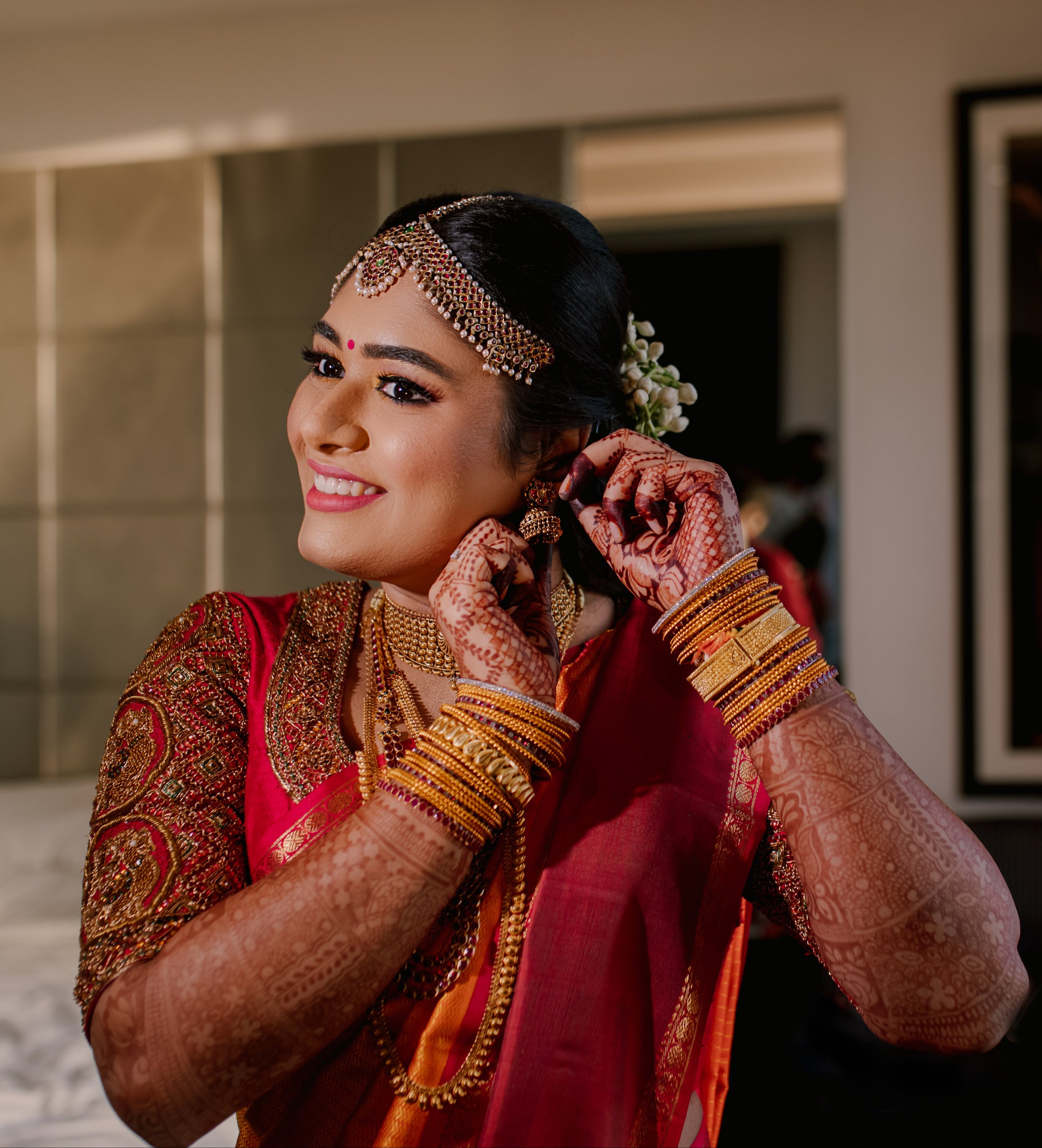 Bride Varshini in a handcrafted red silk blouse designed by Archana Karthick. She is wearing her jewlery.