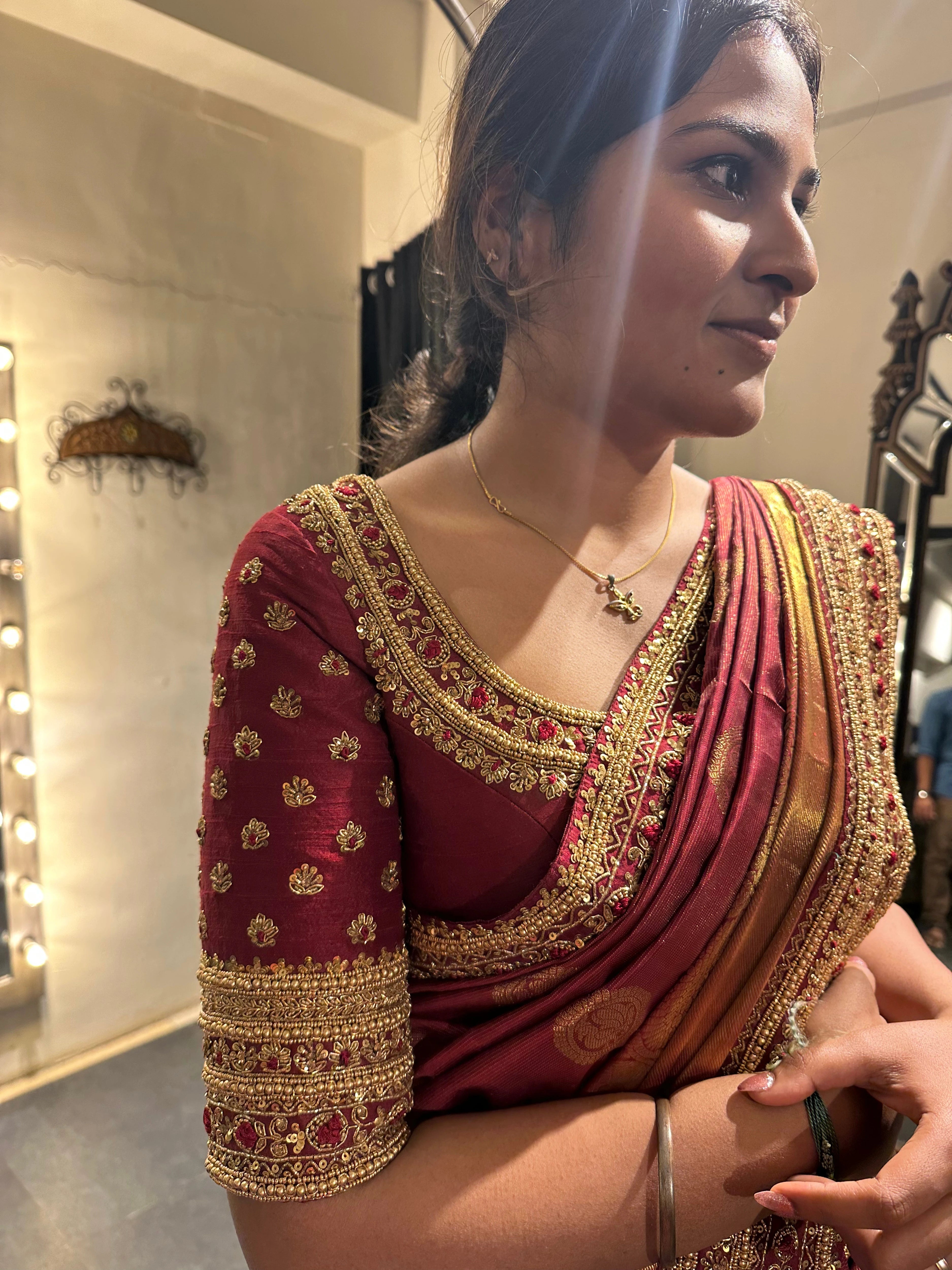 Bride Vidhyashree Ravi posing in a maroon silk blouse and saree border handcrafted by team Archana Karthick.