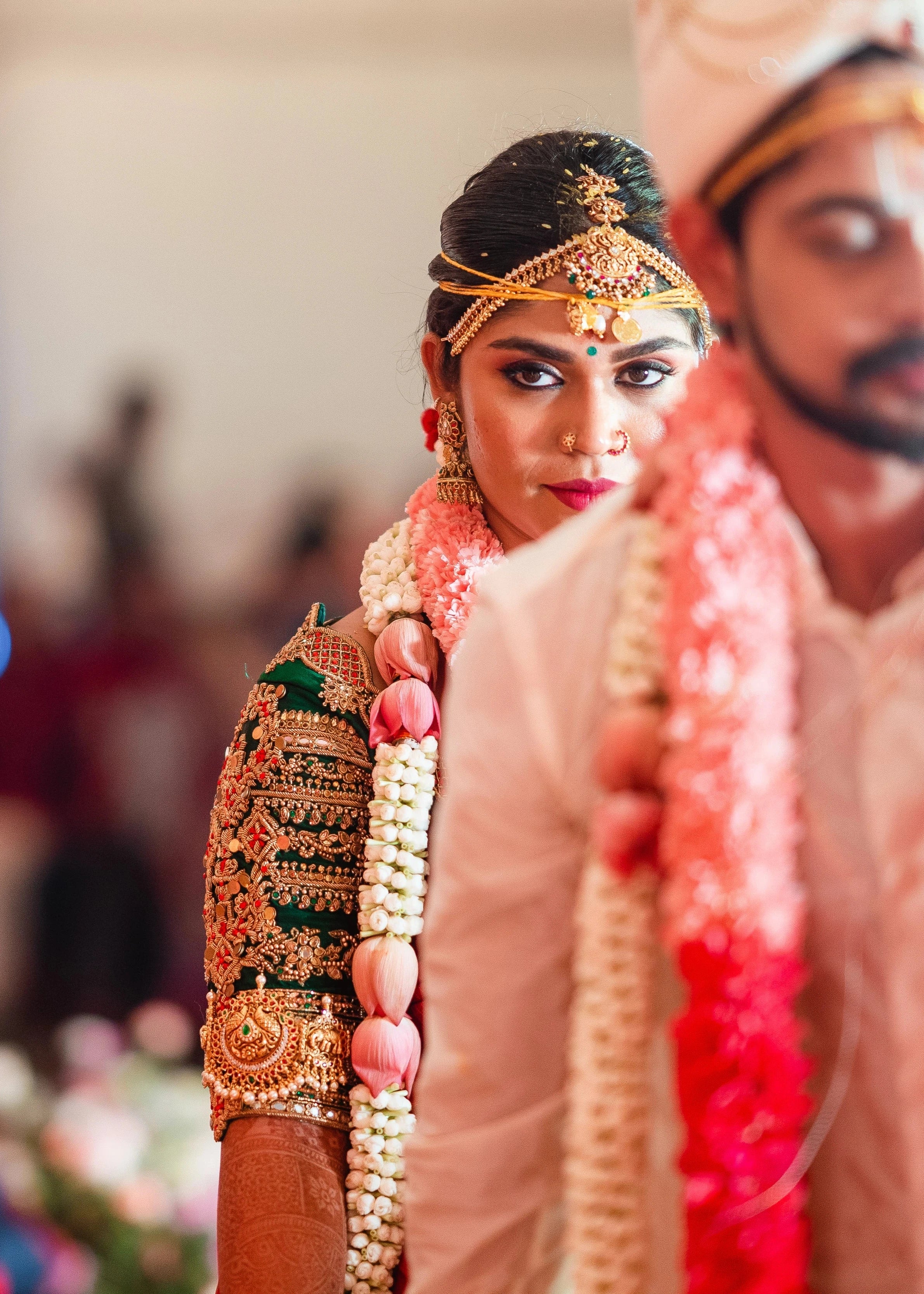 Bride Vidya D posing during ritual in a bottle green silk blouse, handcrafted with beads, zardozi, kundan, resham, stones and coins by team Archana Karthick.
