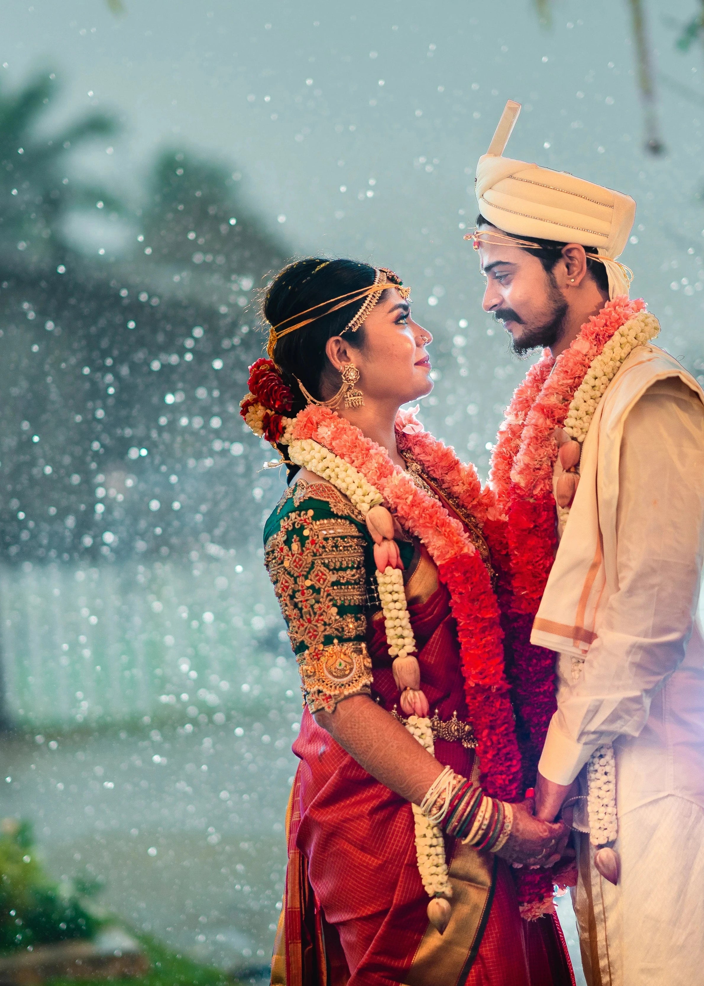 Bride Vidya D smiling with groom in a bottle green silk blouse, handcrafted with beads, zardozi, kundan, resham, stones and coins by team Archana Karthick.