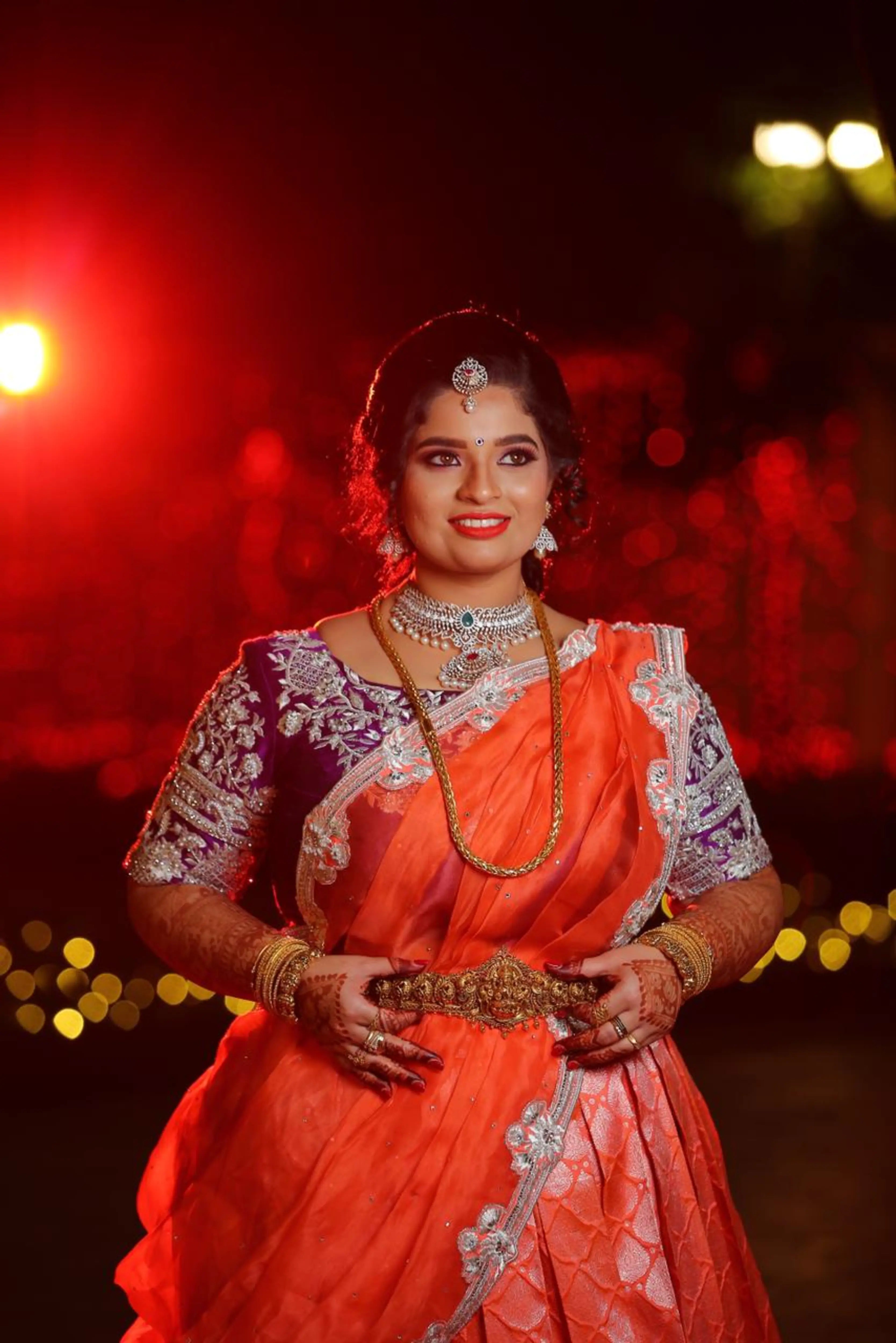 Bride Vishnulakshmi smiling in a purple raw silk blouse and saree border, handcrafted with beads, zari, stones, pearls and sequins by team Archana Karthick.