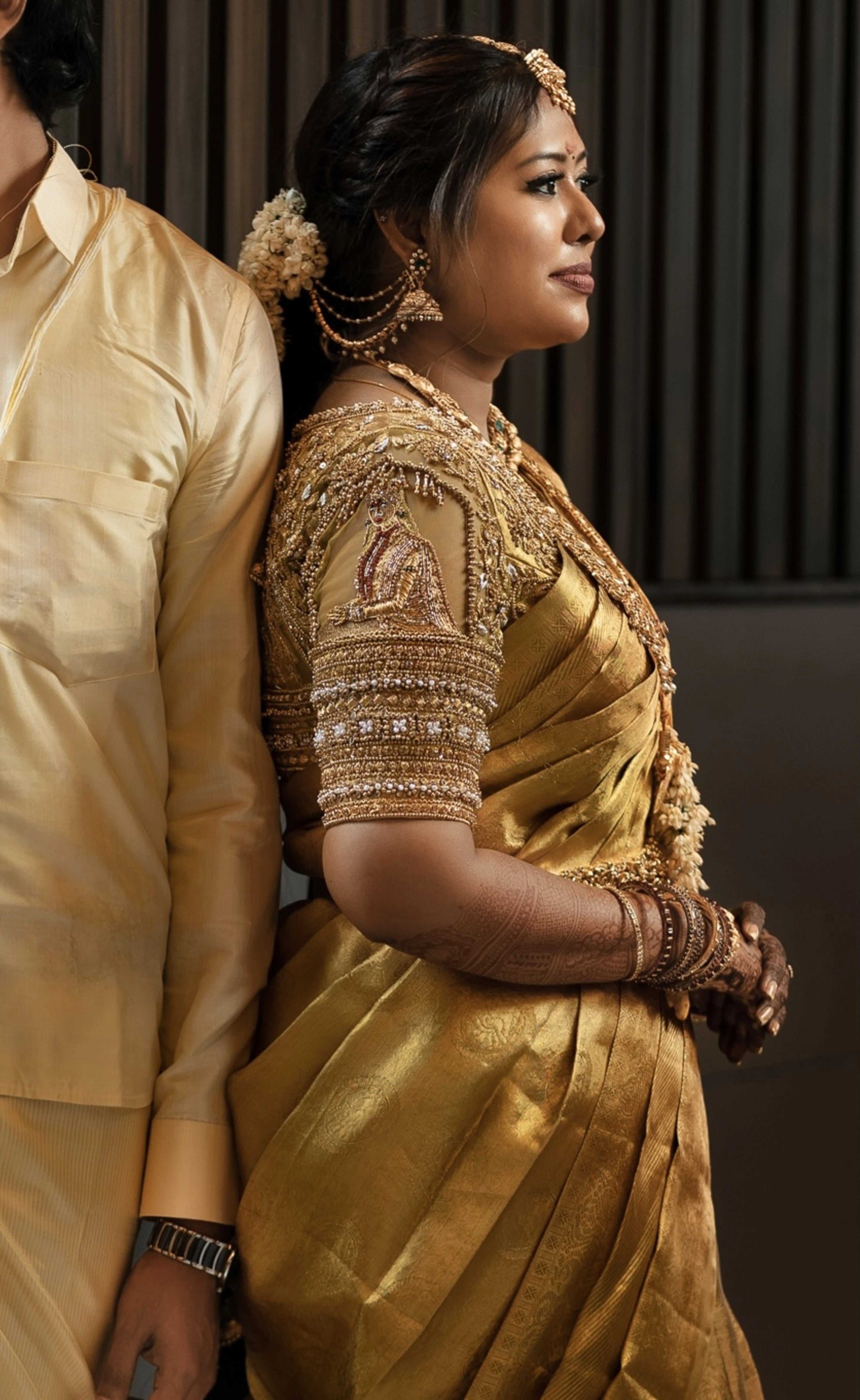 Bride Vishu Priya in a gold silk blouse, handcrafted by team Archana Karthick.