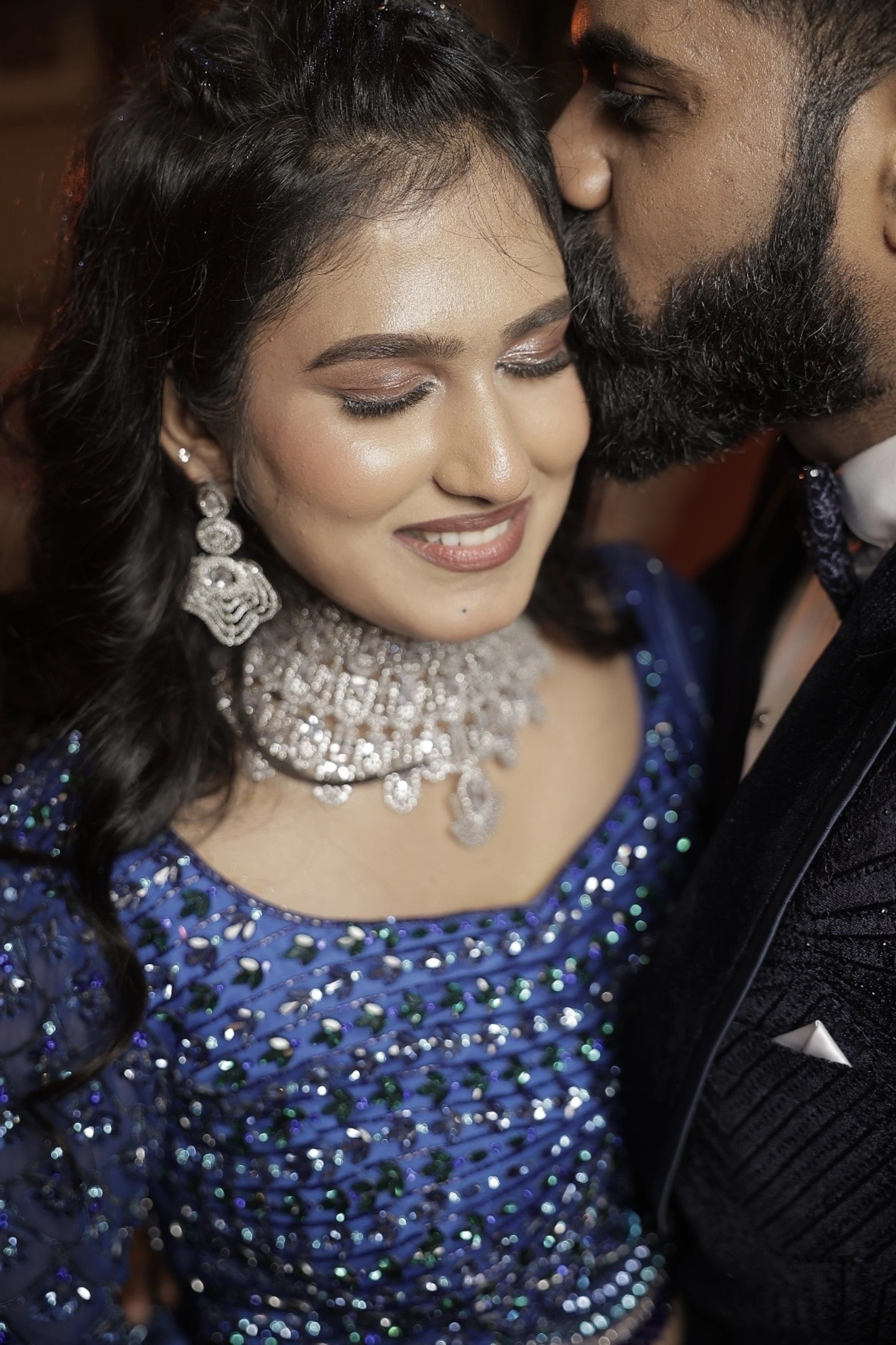 Bride and groom in a peacock themed blue ombre tulle lehenga, handcrafted with sequins, cutdana, rhinestones and feathers by team Archana Karthick.
