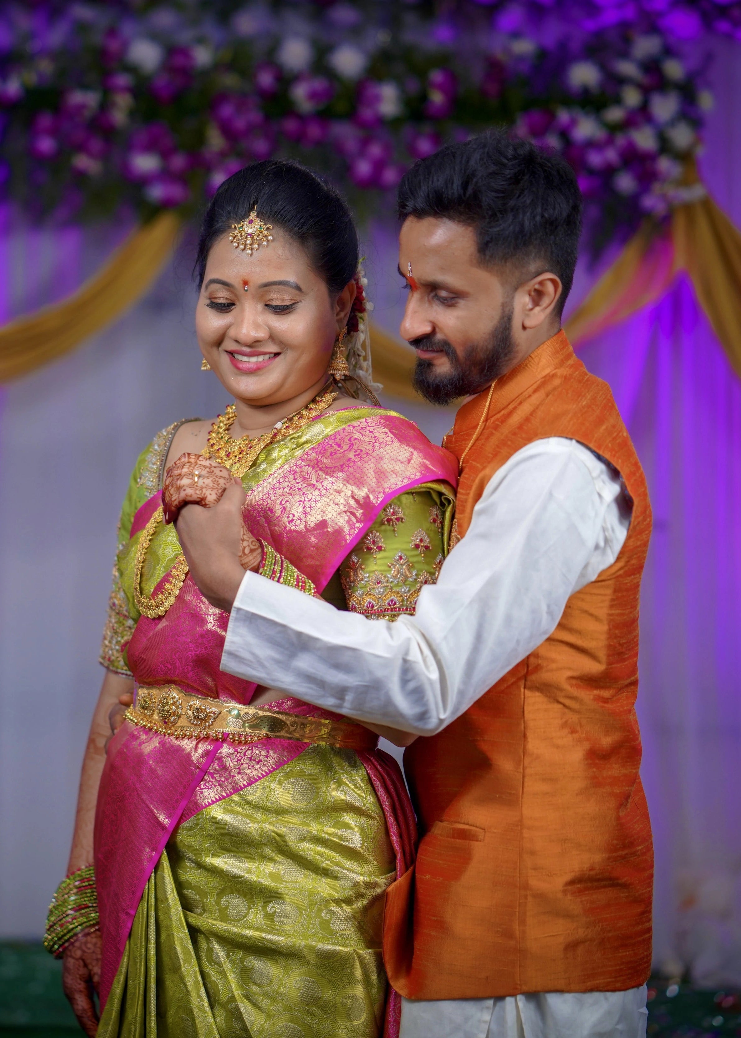 Bride and groom from Seattle, USA posing in a handcrafted blouse and bandhgala set designed by Archana Karthick.