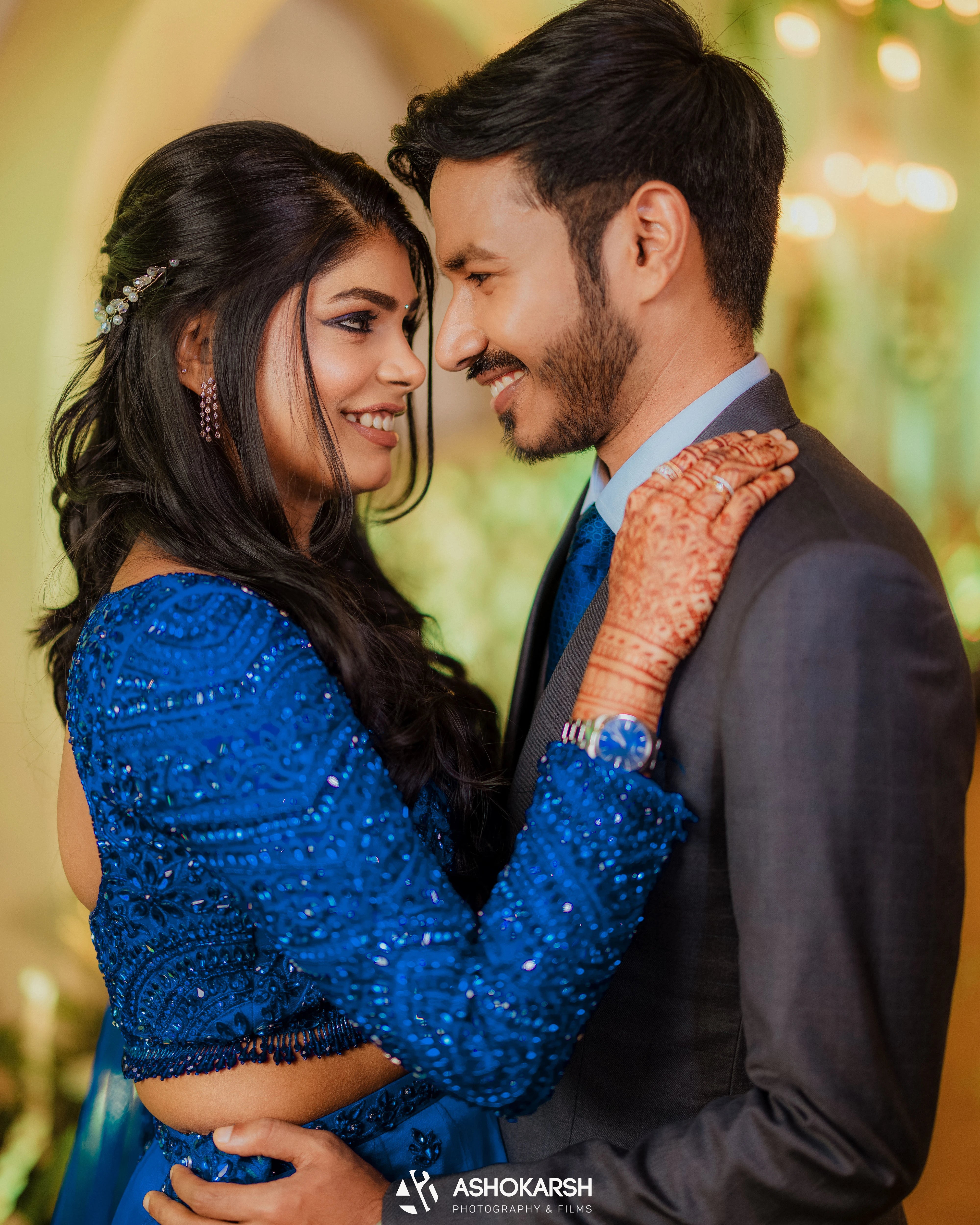Bride Snegha from Australia smiling with groom in a blue tulle lehenga, handcrafted with sequins, cutdana, rhinestones and crystals by team Archana Karthick.