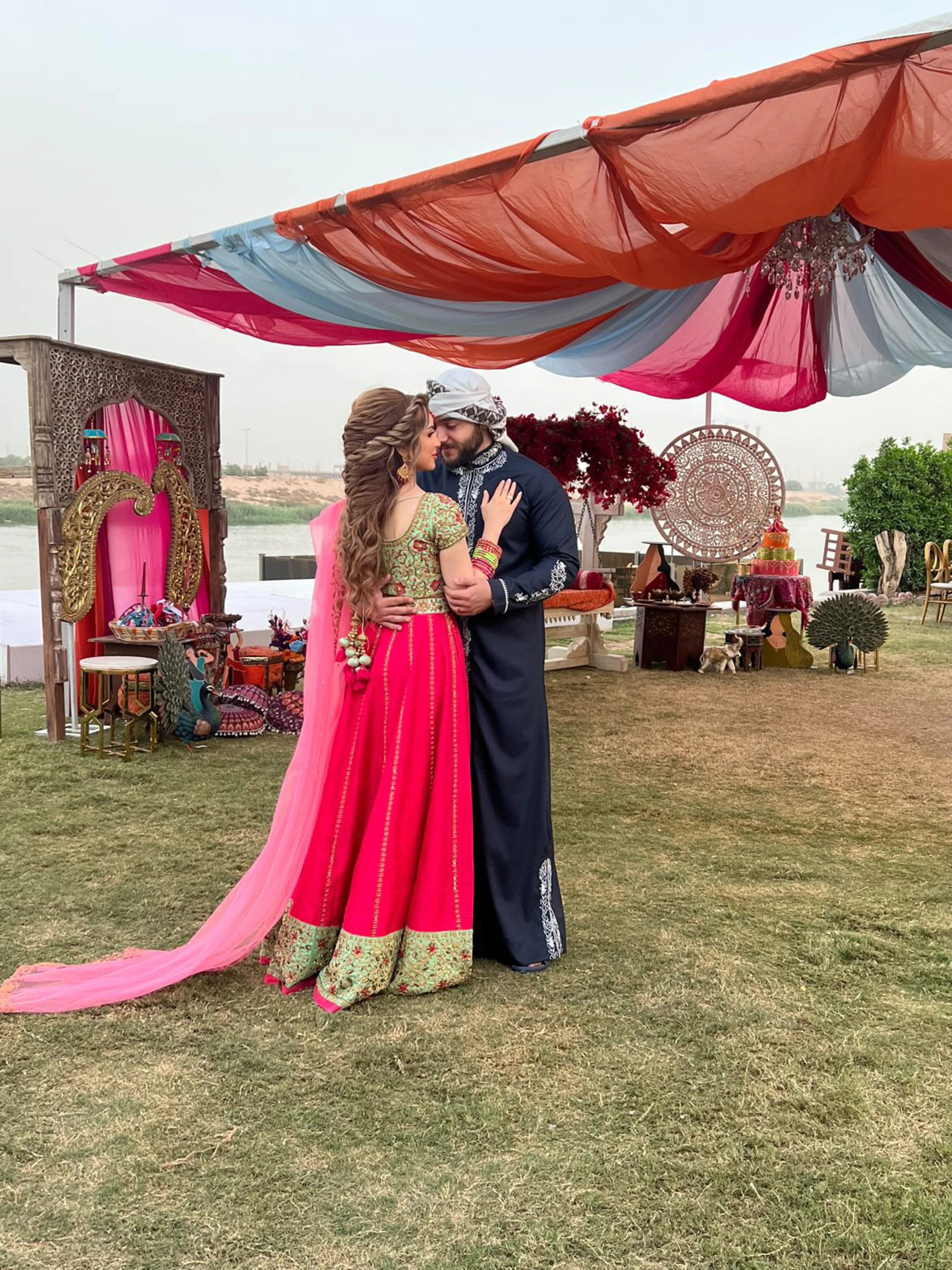Bride from Baghdad, Iraq posing in a hot pink and mint green raw silk lehenga, handcrafted by team Archana Karthick.