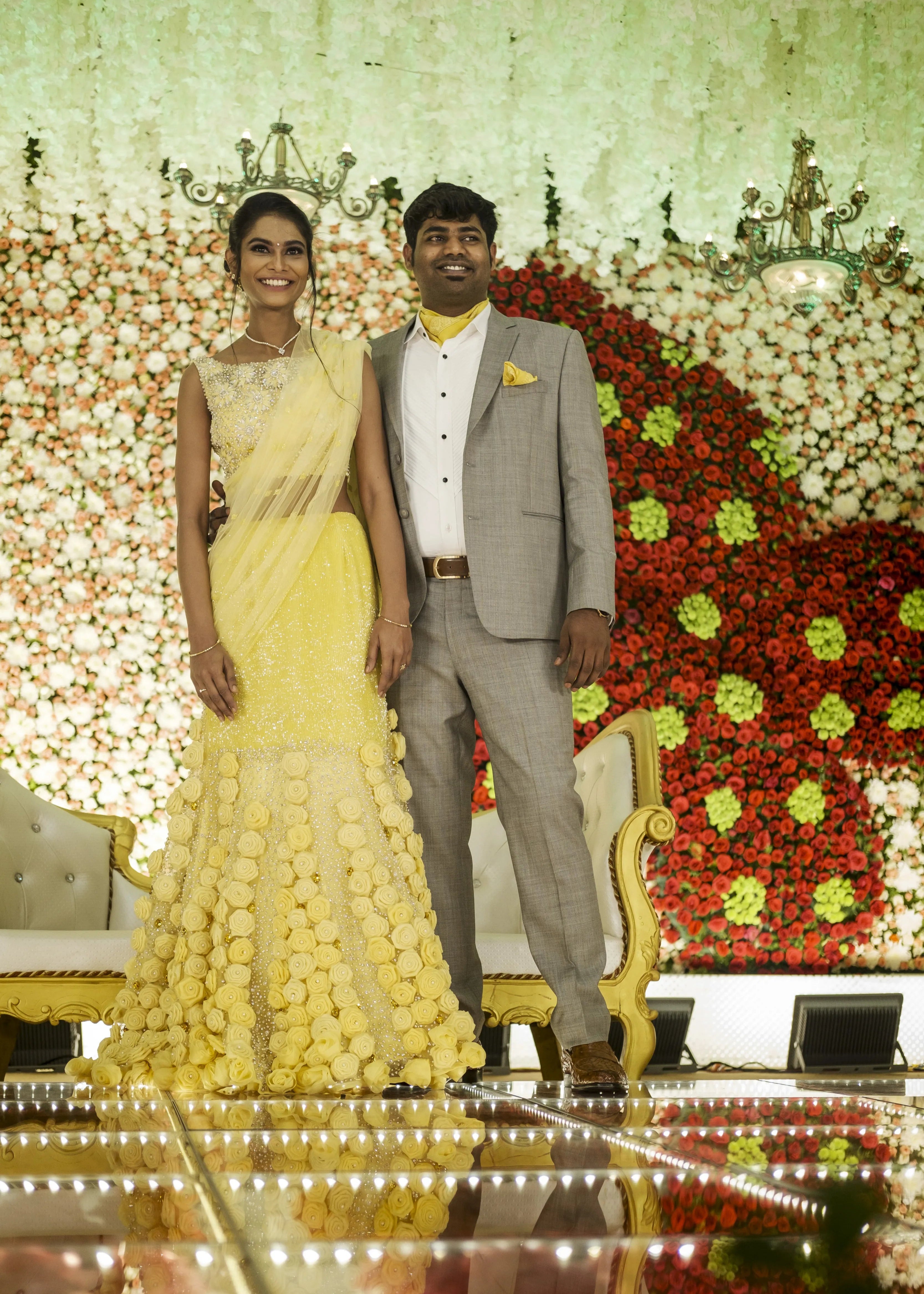 Bride from Chennai on stage with groom in handcrafted yellow mermaid lehenga embellished with cut dana, pearls, rhinestones and handmade 3D flowers.