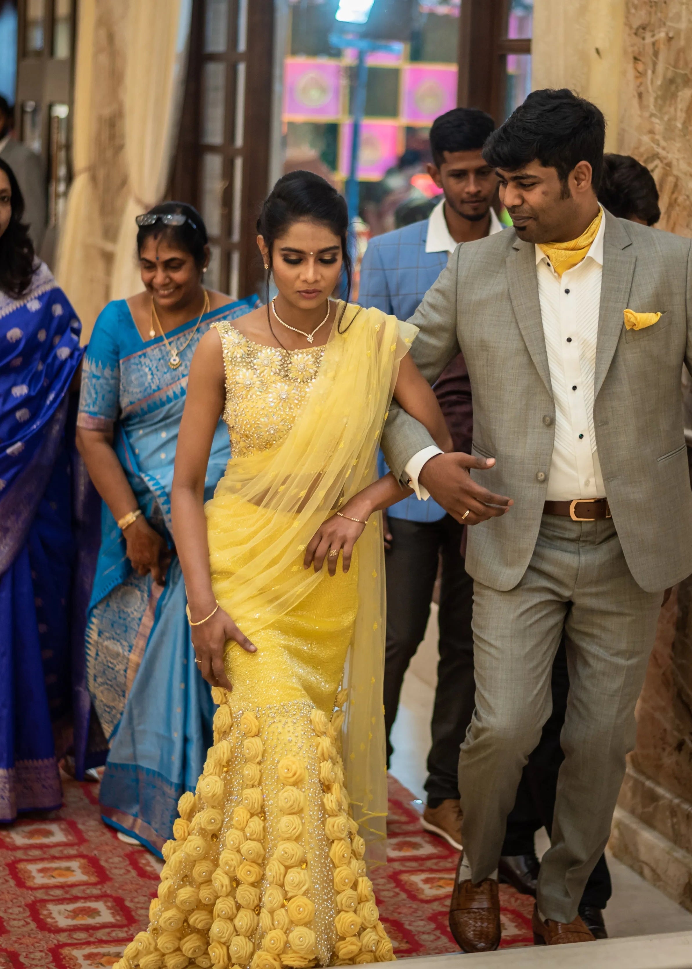 Bride from Chennai posing with groom in handcrafted yellow mermaid lehenga embellished with cut dana, pearls, rhinestones and handmade 3D flowers.