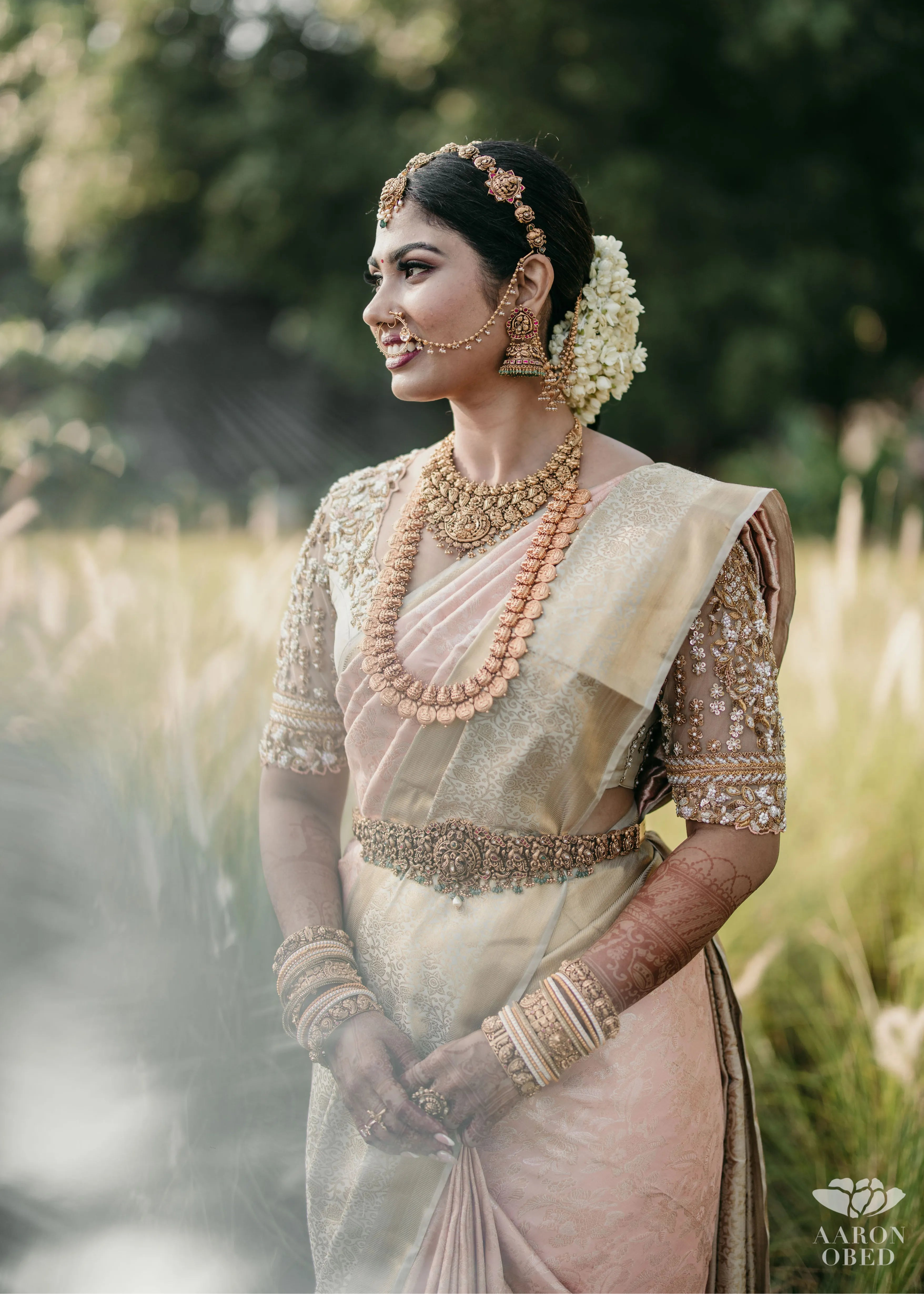 Bride from Chennai smiling in a concept blouse in grey tulle and silk, handcrafted intricately with zardozi, crystal beads, stones, pearls and beads. Designed by Archana Karthick.