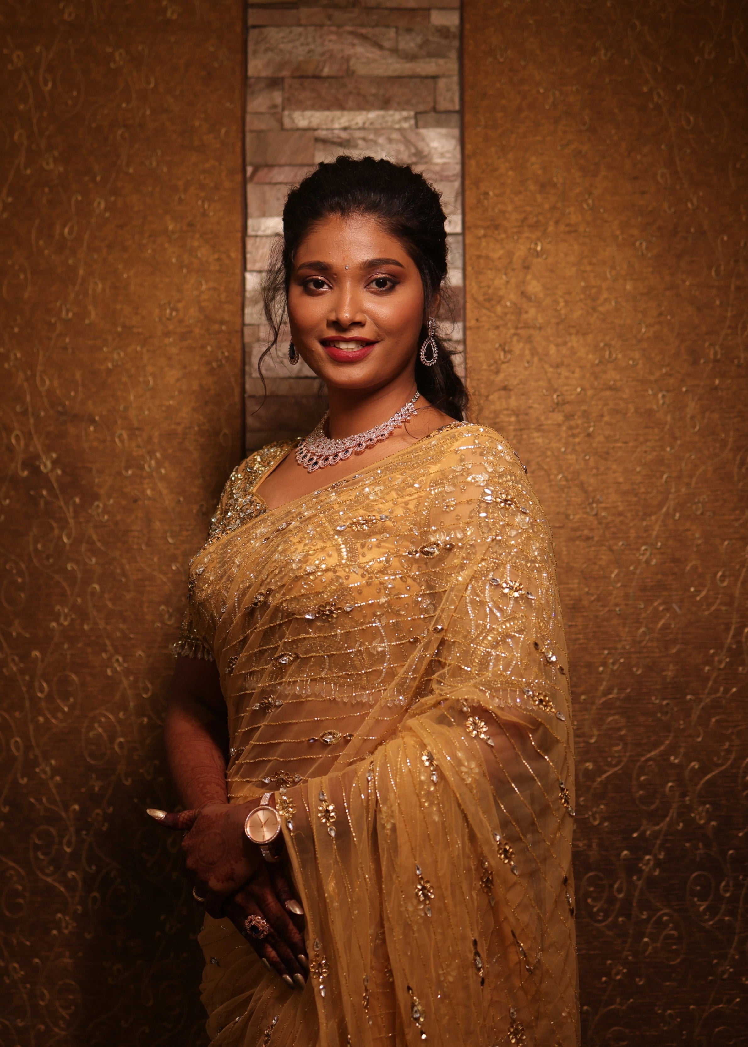Bride from Chennai smiling in a handcrafted metallic gold net saree designed by Archana Karthick with rhinestones