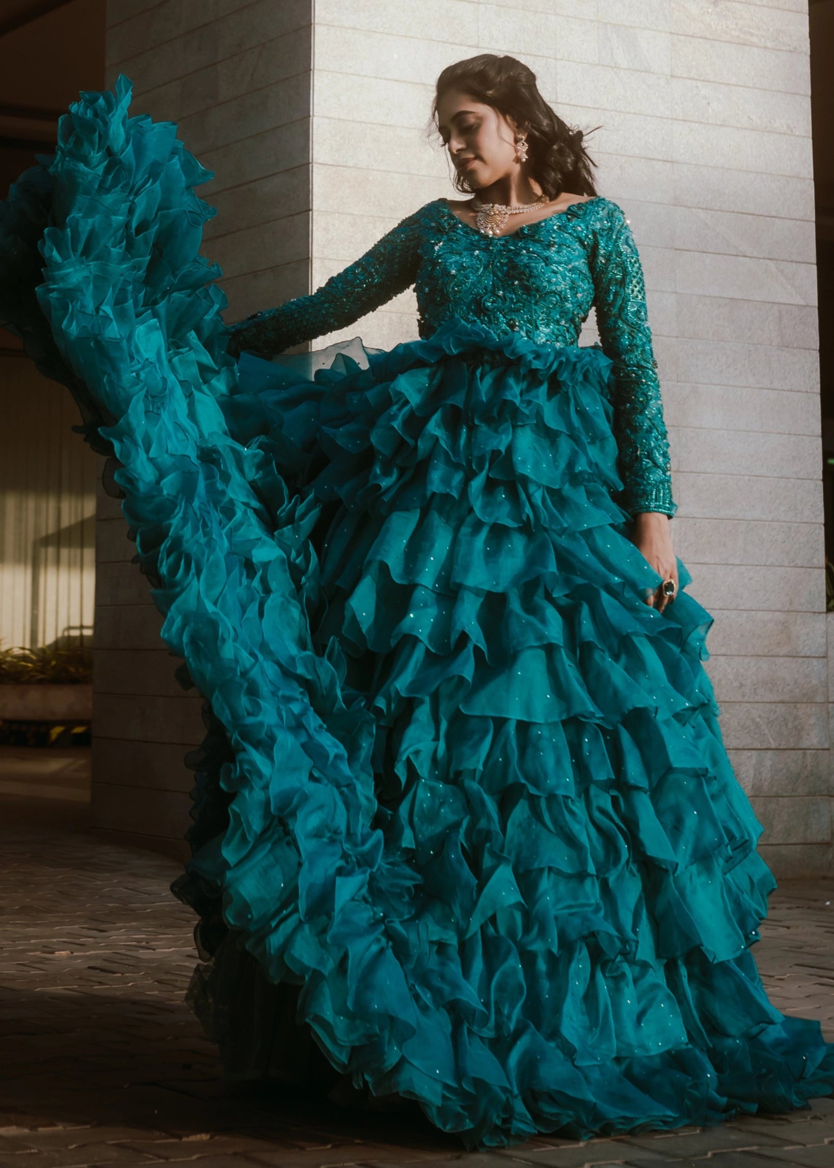 Bride from Coimbatore in a pleasted and layered gown handcrafted with stones, rhinestones, cutdanas, sequins and appliques designed by Archana Karthick.