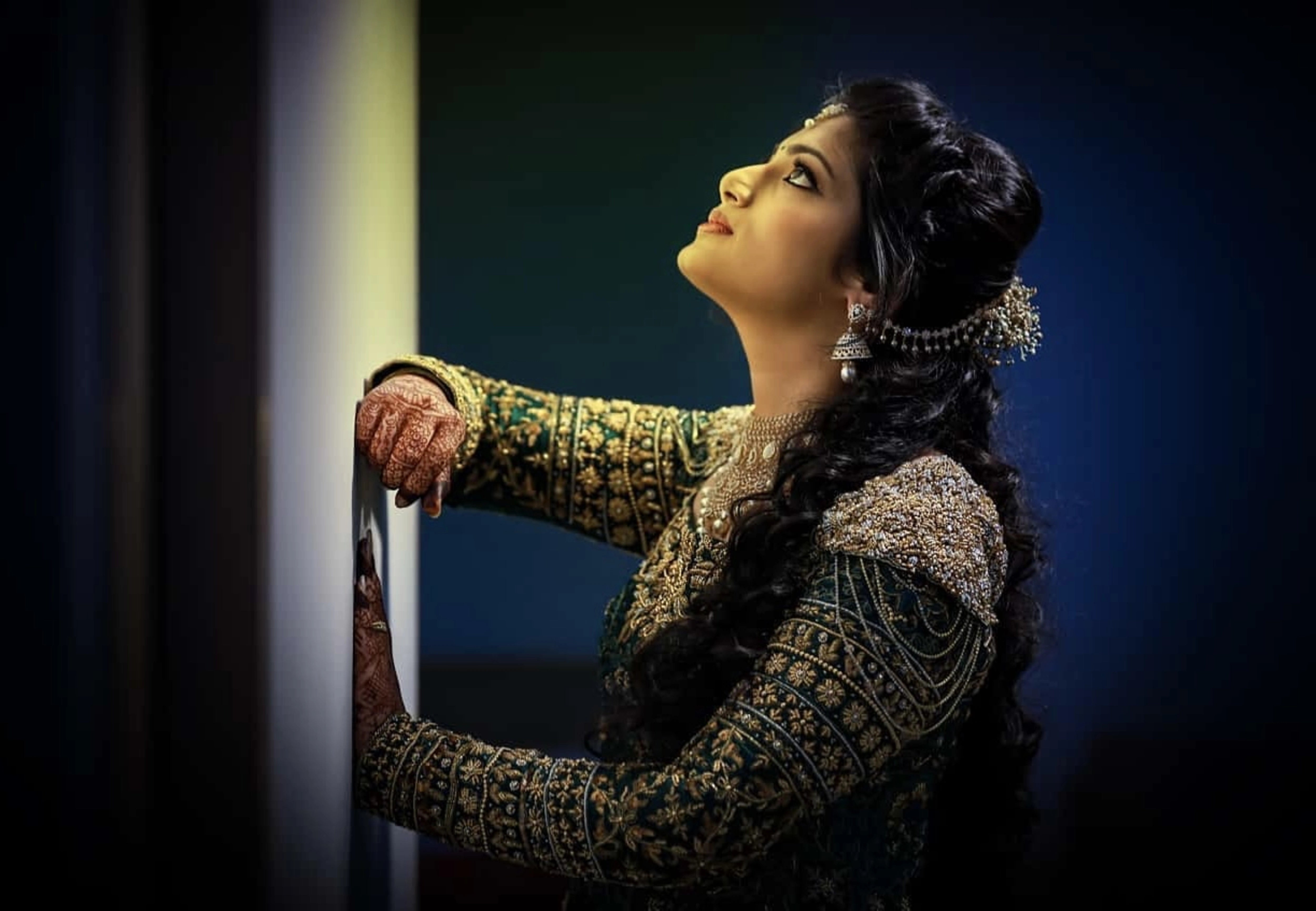 Bride from Kuwait posing for photoshoot in a bottle green satin silk masakali lehenga handcrafted with zardozi, rhinestones, crystals and more. Designed by Archana Karthick.