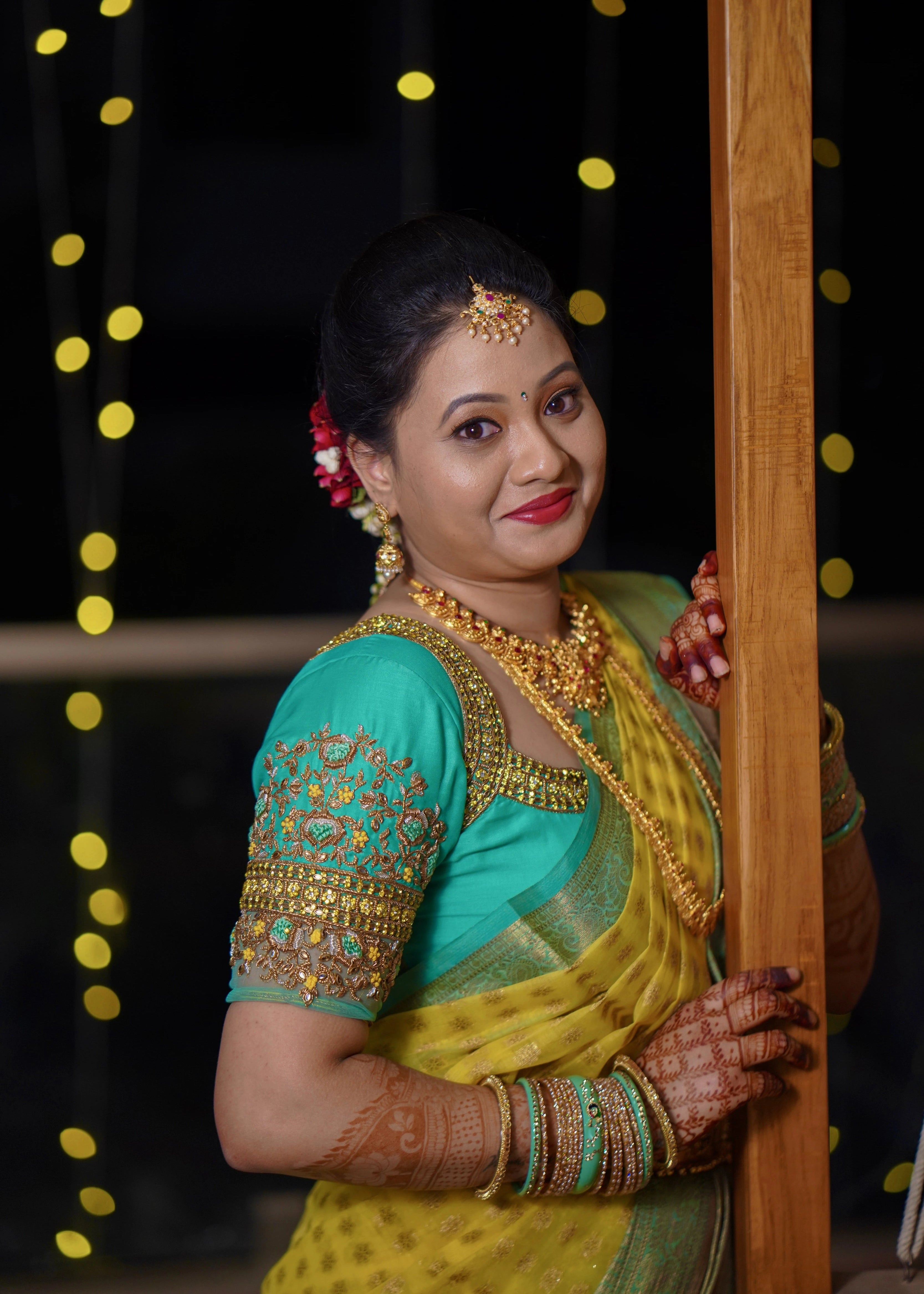 Bride from Seattle smiling in an aquamarine blouse designed by Archana Karthick