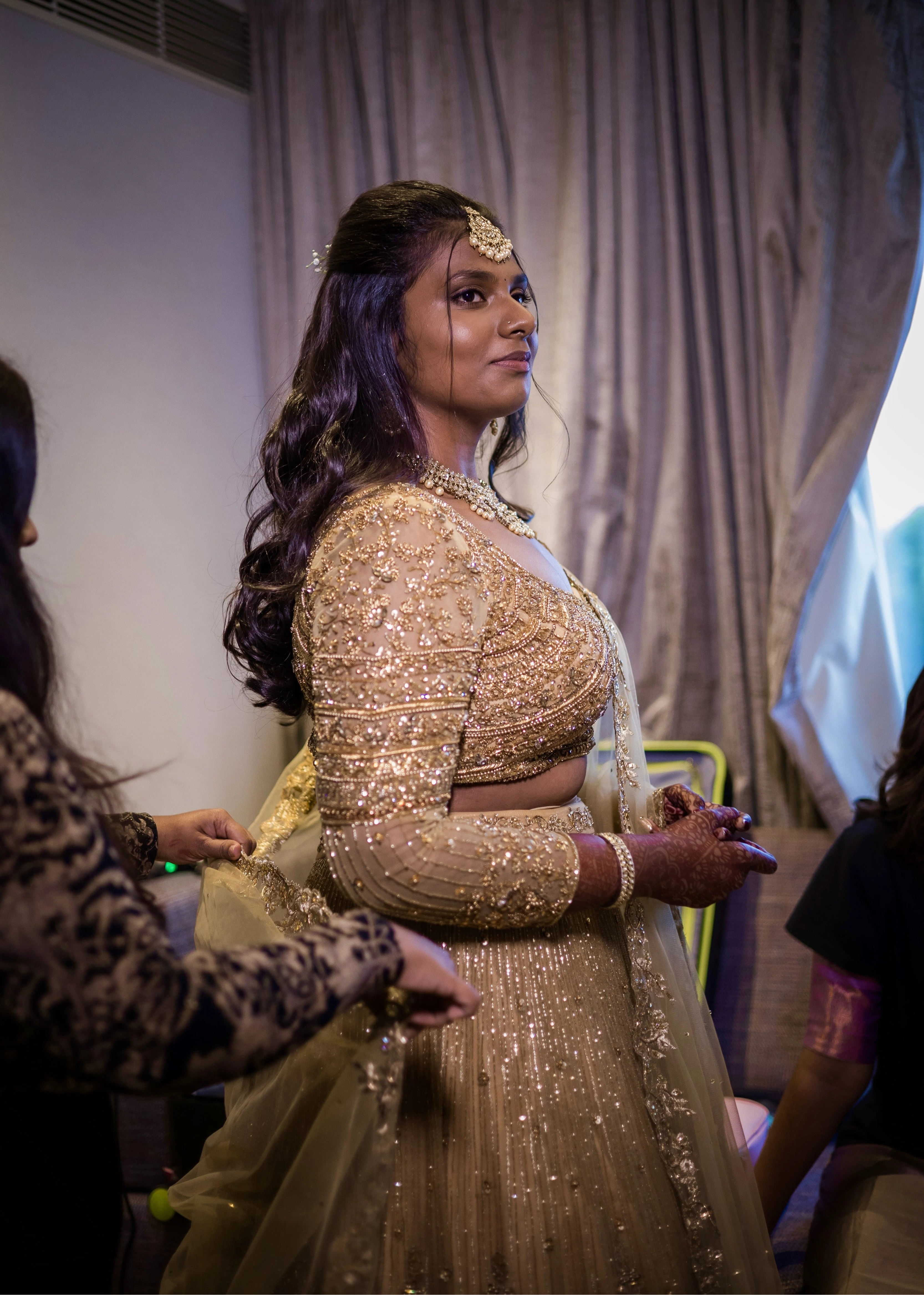 Bride from Singapore during makeup in a gold lehenga in tulle designed by Archana Karthick handcrafted intricately with rhinestones, crystal beads, cutdanas and sequins.