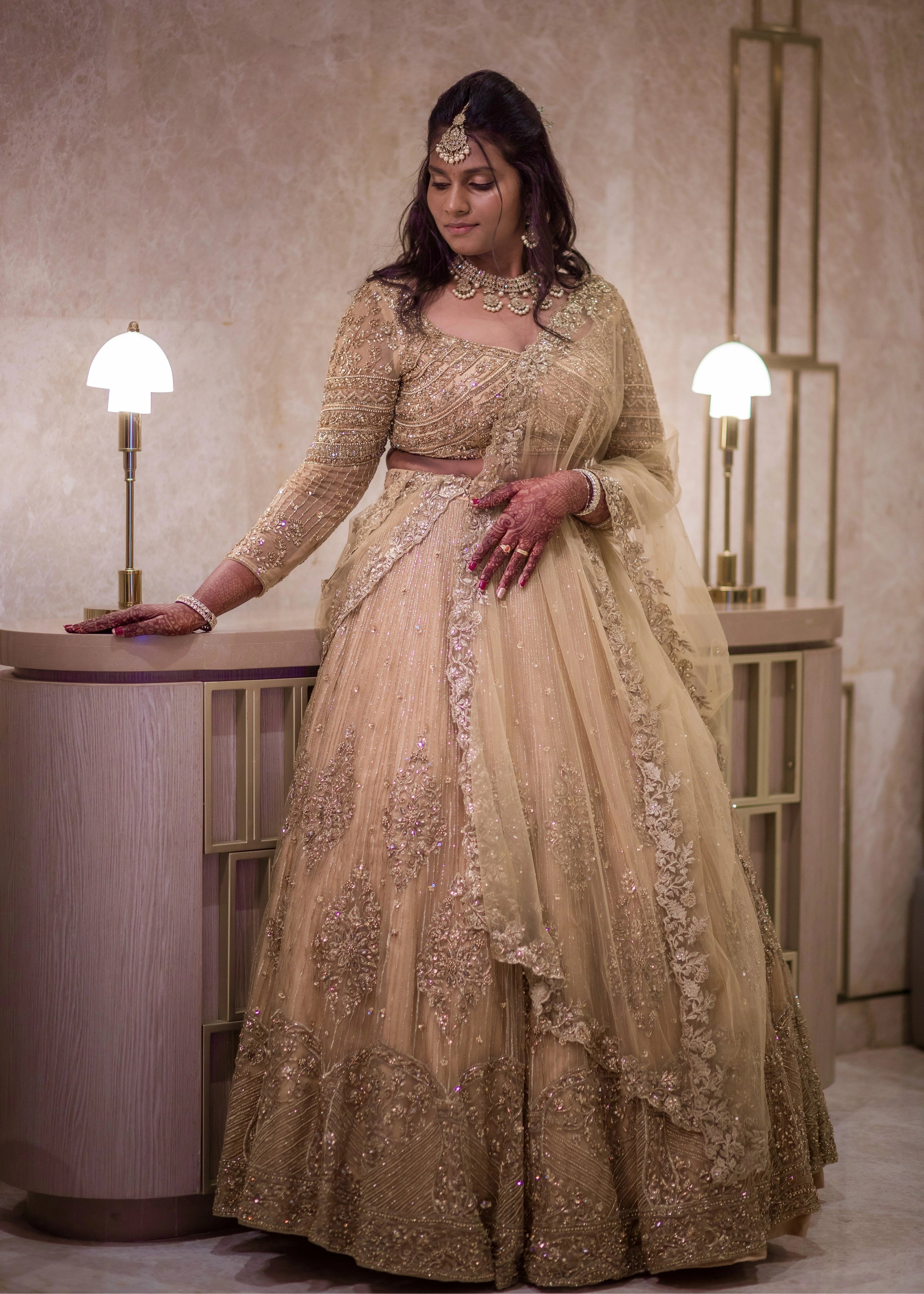 Bride from Singapore in a gold lehenga in tulle designed by Archana Karthick handcrafted intricately with rhinestones, crystal beads, cutdanas and sequins.