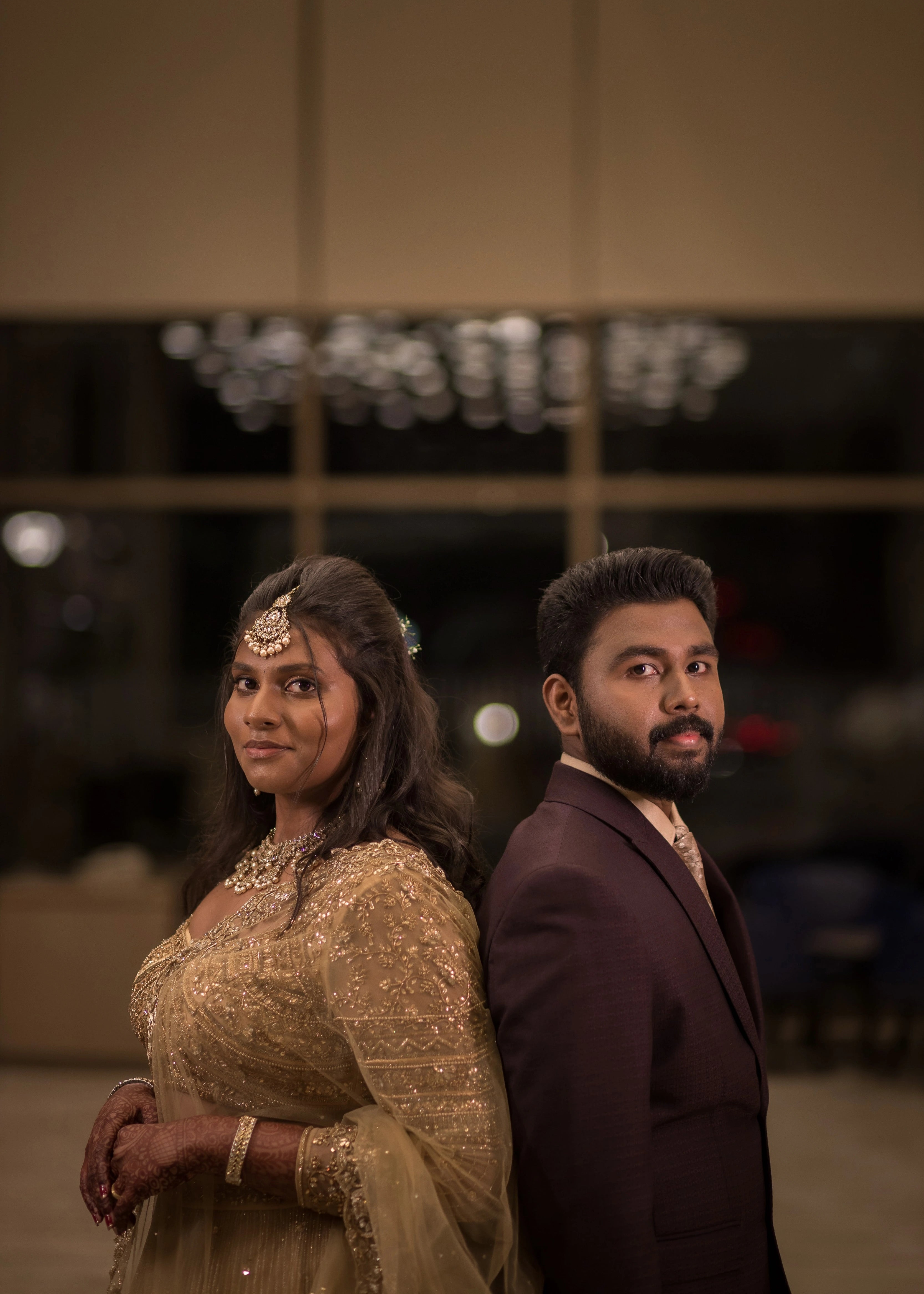 Bride from Singapore posing in a gold lehenga in tulle designed by Archana Karthick handcrafted intricately with rhinestones, crystal beads, cutdanas and sequins.